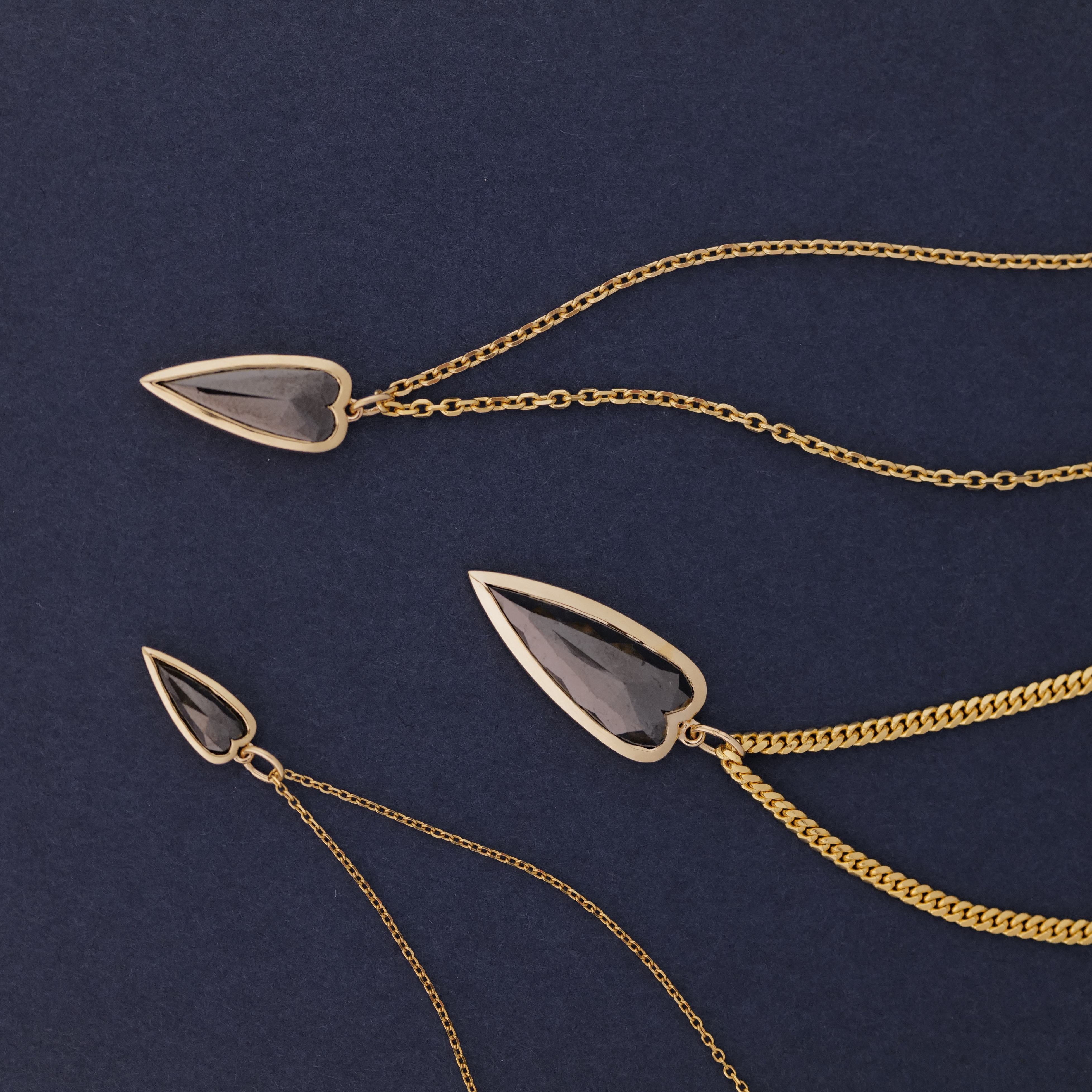 Three Fiat Lux Petite Punk Heart Charm necklaces in 14K gold, shown on a dark blue background.