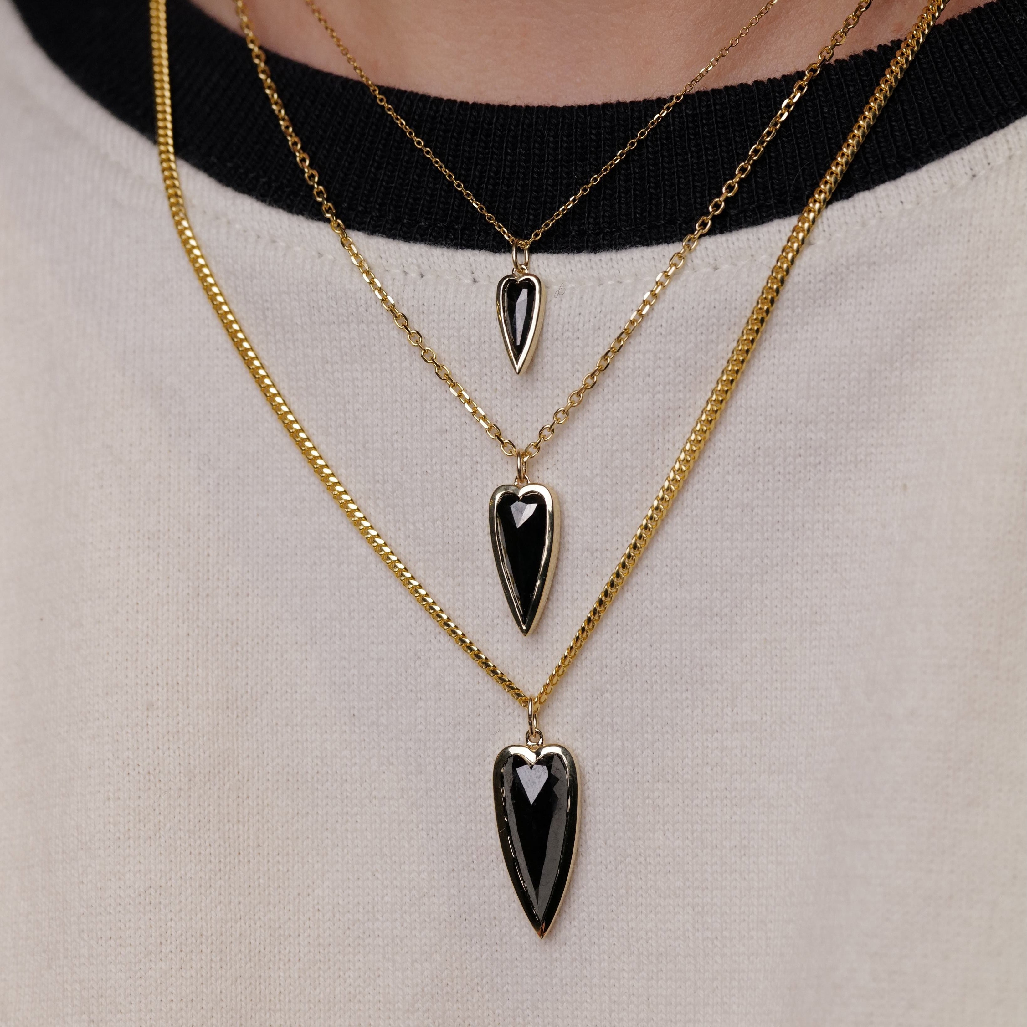 Fiat Luxs Petite Punk Heart Charm: three-layered 14K gold necklaces with black heart pendants.