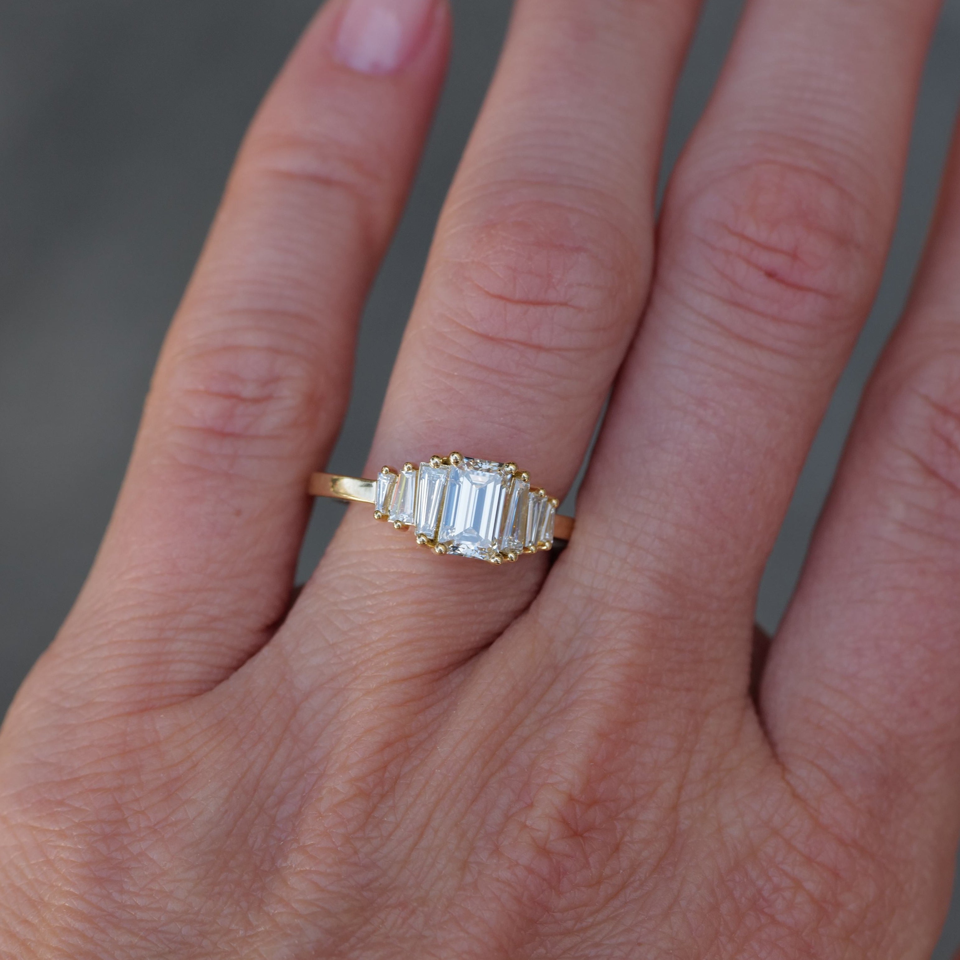 A Classic Calypso - Emerald Cut Diamond (1.02ct) ring by Fiat Lux is worn on a person’s ring finger.