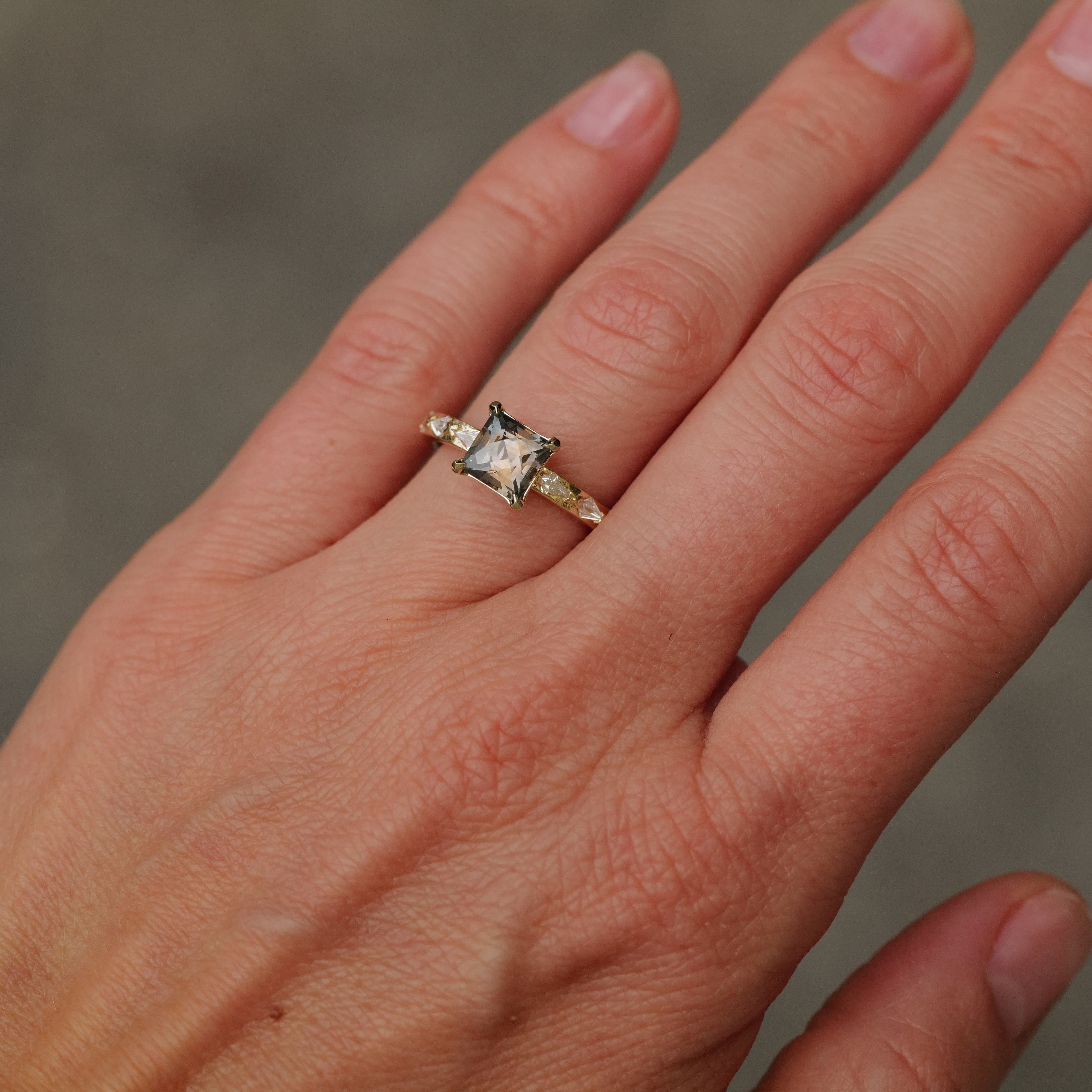 A hand wears Fiat Luxs Classic Theia Ring—1.70ct plum sapphire set in 14K gold—on the ring finger, neutral backdrop.