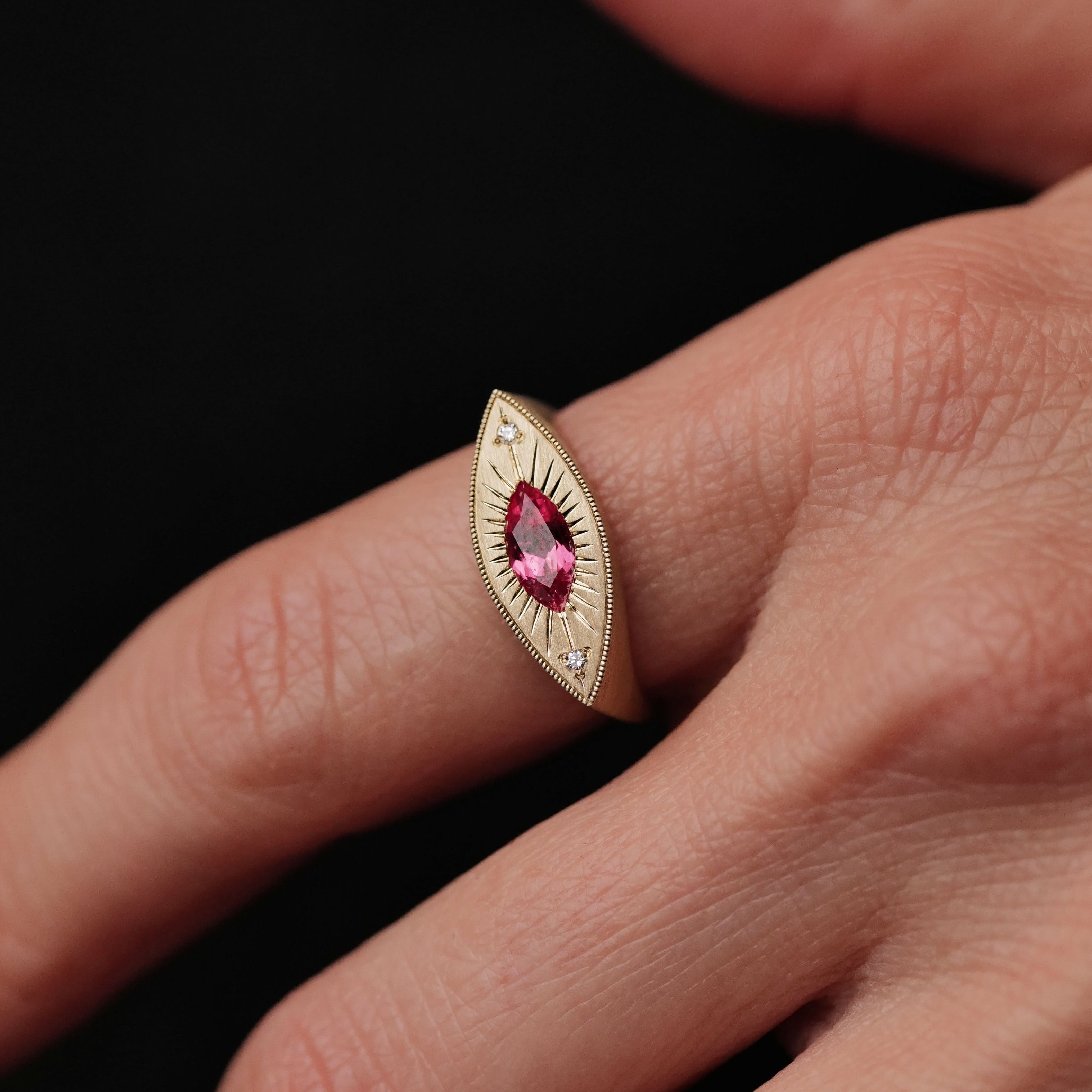 A person wears Fiat Luxs Brilliant Third Eye ring featuring a 0.63ct Summer Coral sapphire and diamonds.