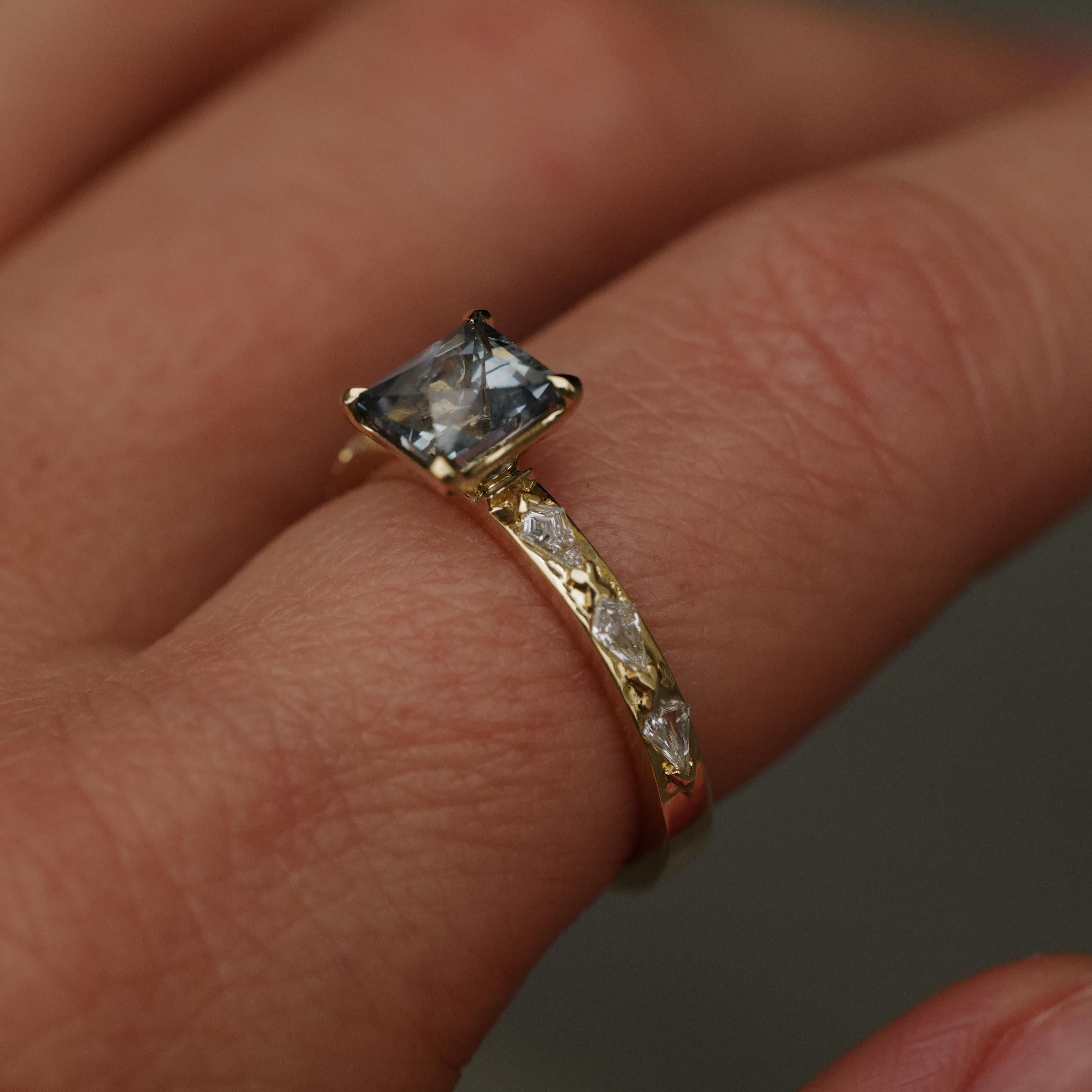 Fiat Lux Classic Theia Ring with 1.41ct aqua sapphire and kite cut diamonds in 14K gold on a persons finger.