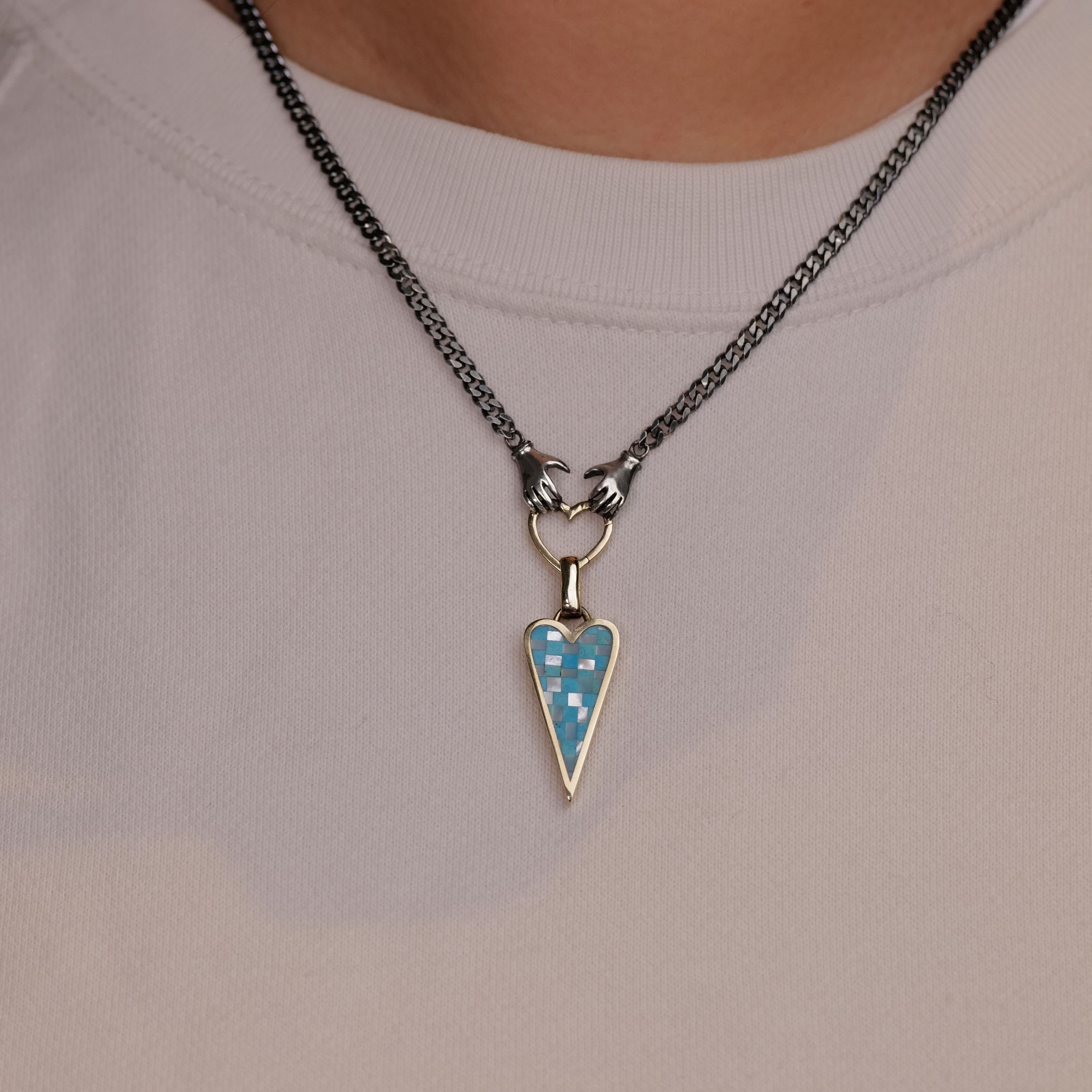 Someone wears the Goodluck Handmade Punk Heart Checkerboard Charm necklace over a light-colored shirt.