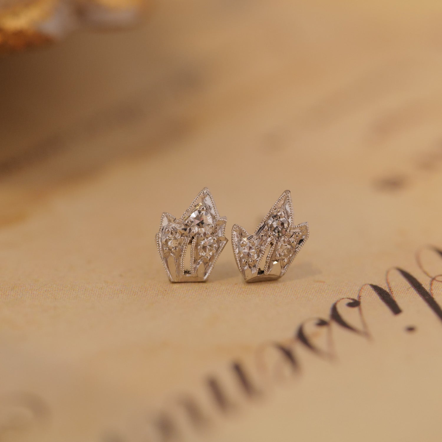 Vintage Platinum Leaf Earring - Diamond by Vintage, perfect for old-world charm, displayed on beige paper.