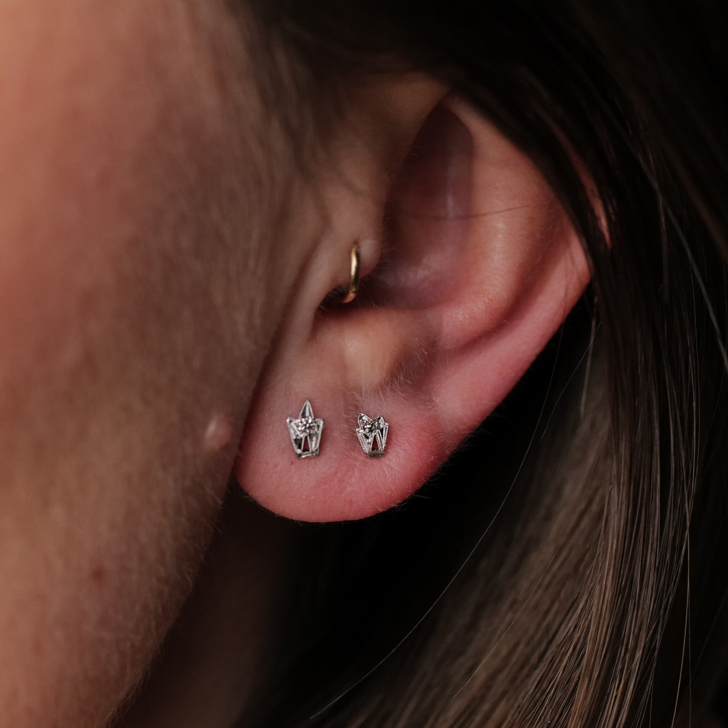 Close-up of ear with Vintage Platinum Leaf Earring - Diamond; brown hair softly frames the sparkling vintage jewelry.