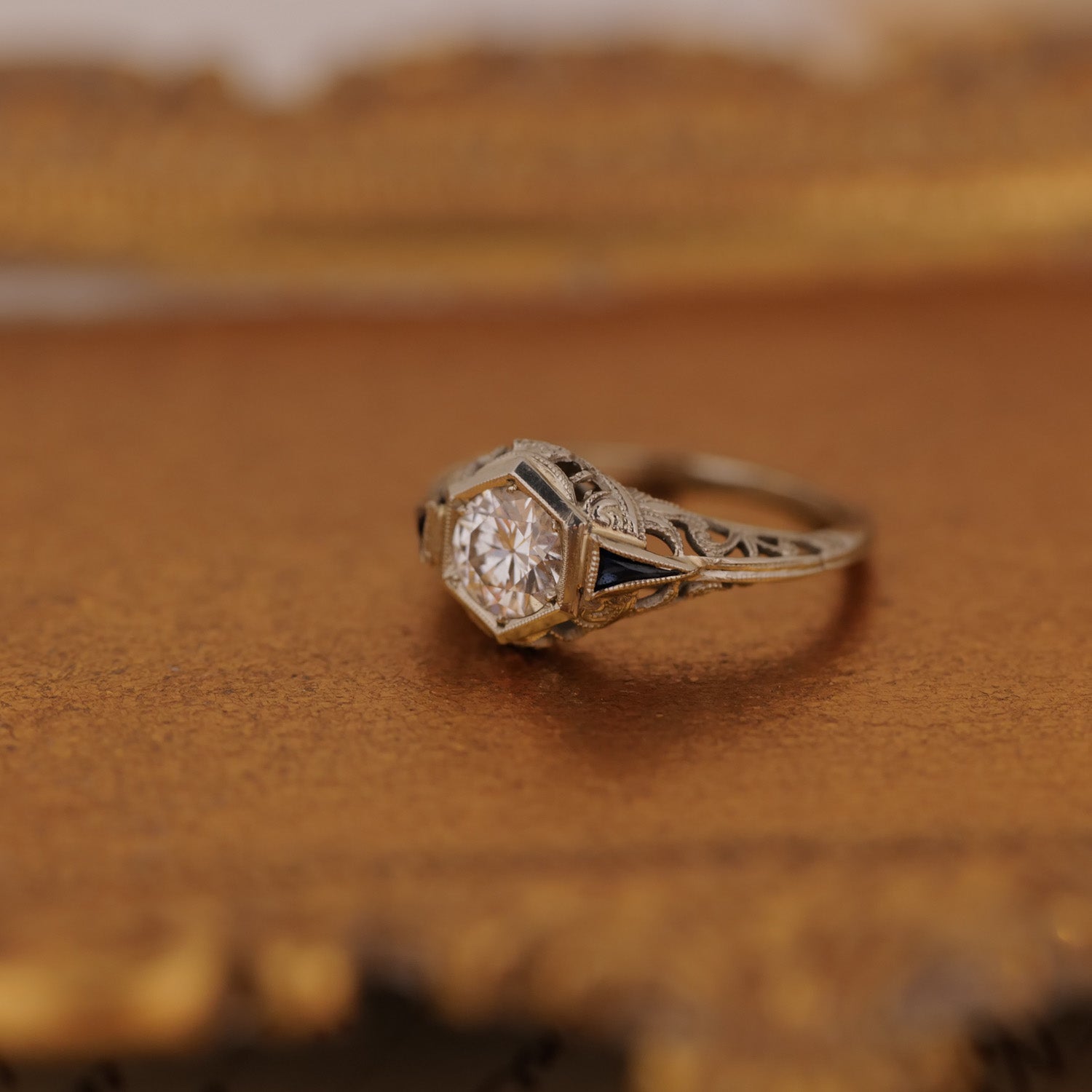 A vintage gem: the Art Deco Botanical Hexagon Ring by Vintage glows atop a gold-toned surface.