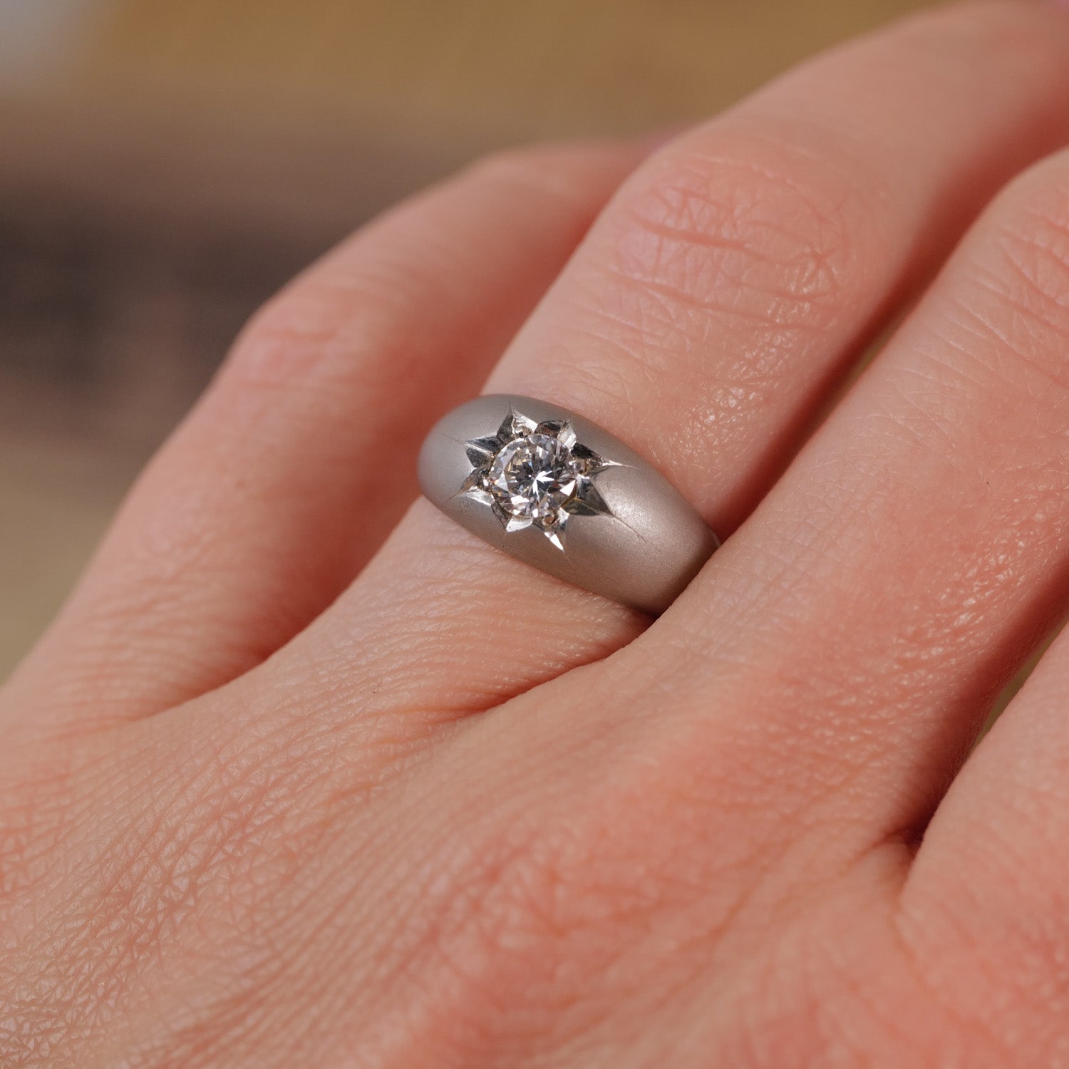 A close-up of a hand wearing the Vintage Star Set Diamond Platinum Ring by Vintage.