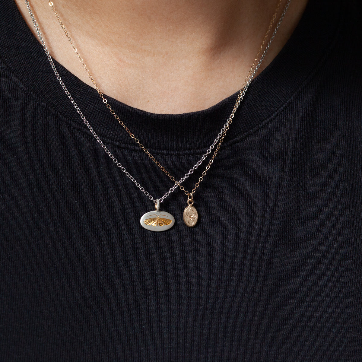 Layer the Tiniest Spider Necklace by Blue Blue Driver over a black shirt for a chic, golden accent.