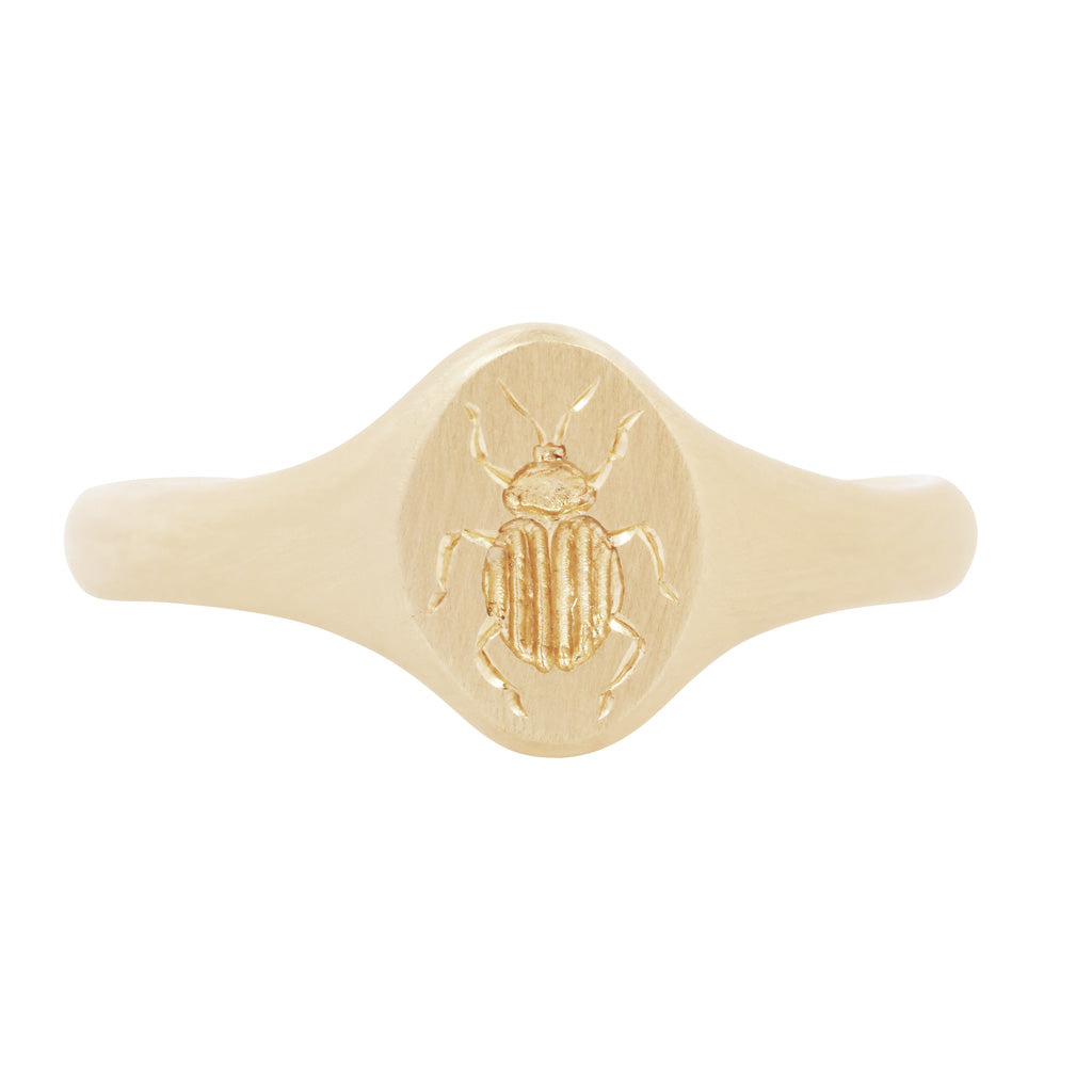 The Tiniest Scarab Signet Ring by Blue Blue Driver is a 14K gold ring engraved with a scarab symbol of renewal.