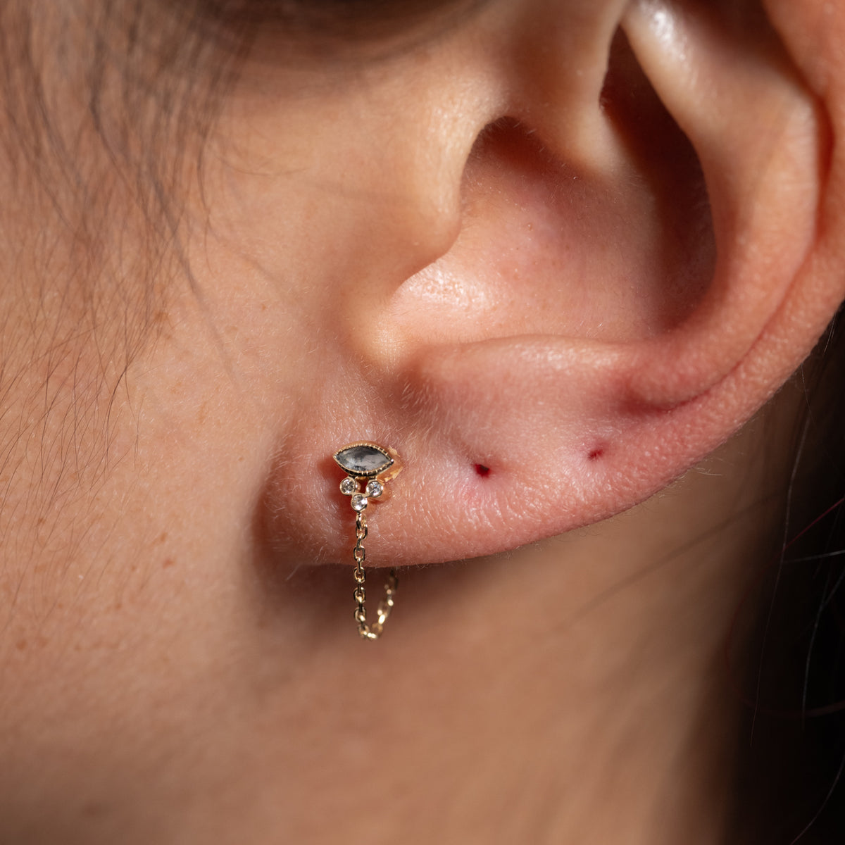 Celine Daoust Single Marquise Chain Earring in 14K gold with a marquise-cut gemstone and three small diamonds.