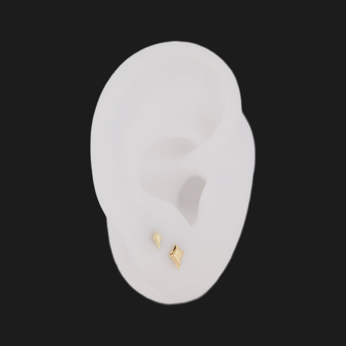 Two 14K gold Classic North Star stud flatback earrings worn on a white ear model.
