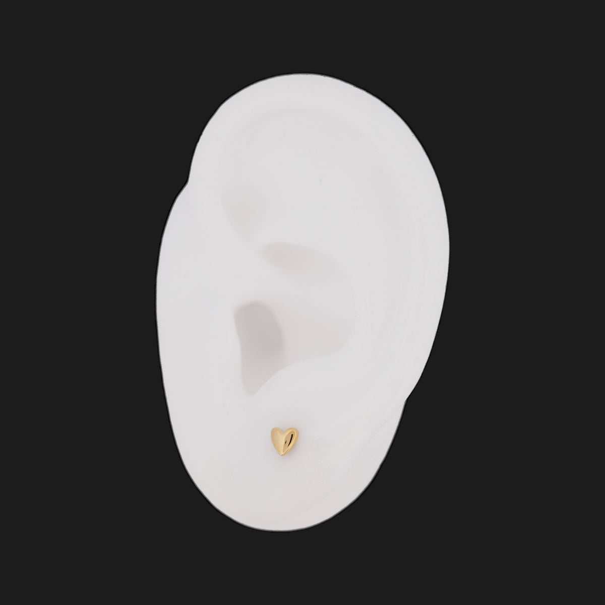 A 14K gold Classic Puffy Heart (4mm) stud earring worn on a white ear model.