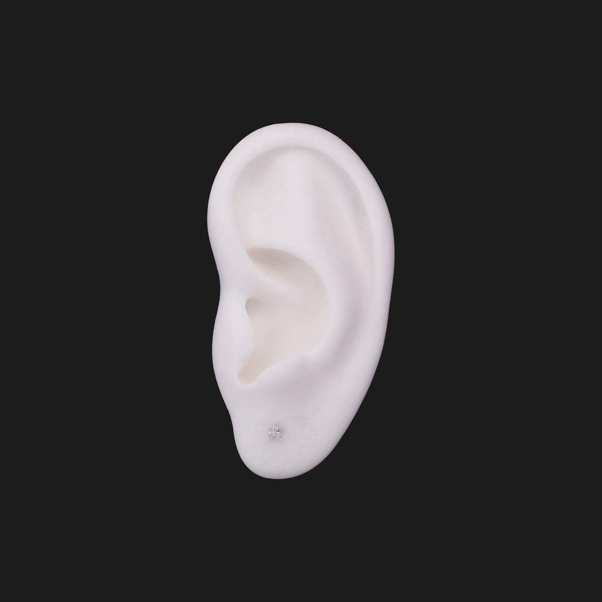 A Fiat Lux 3 Gem Cluster - White Diamond (1mm) 14K gold earring on a white ear model.