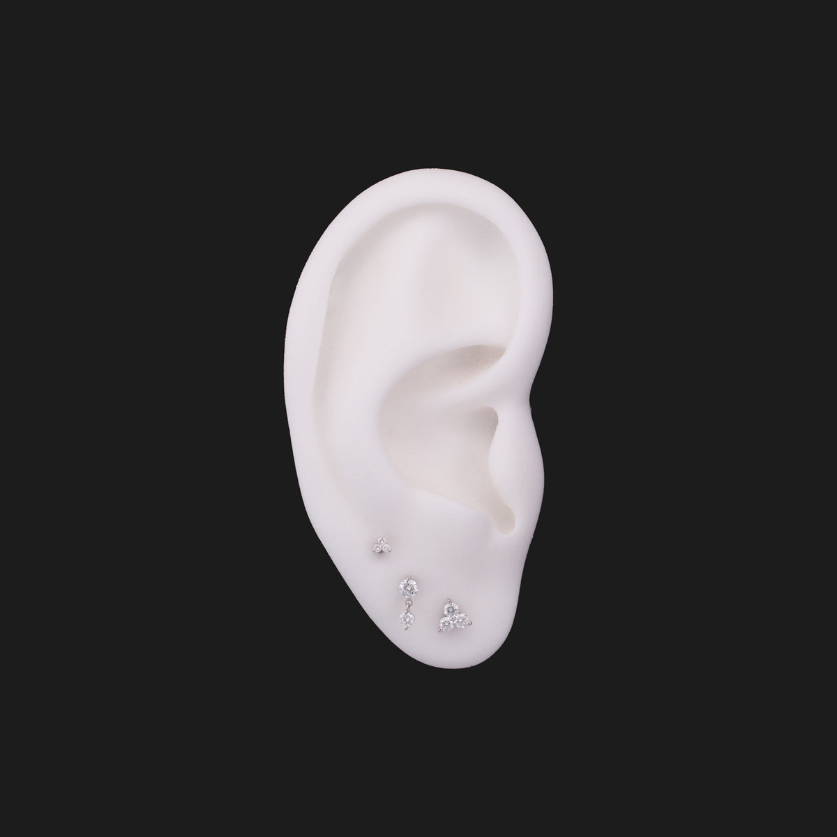 Three Classic Twin Stars - White Diamond (2.5mm) 14K gold stud earrings arranged on a white ear model.