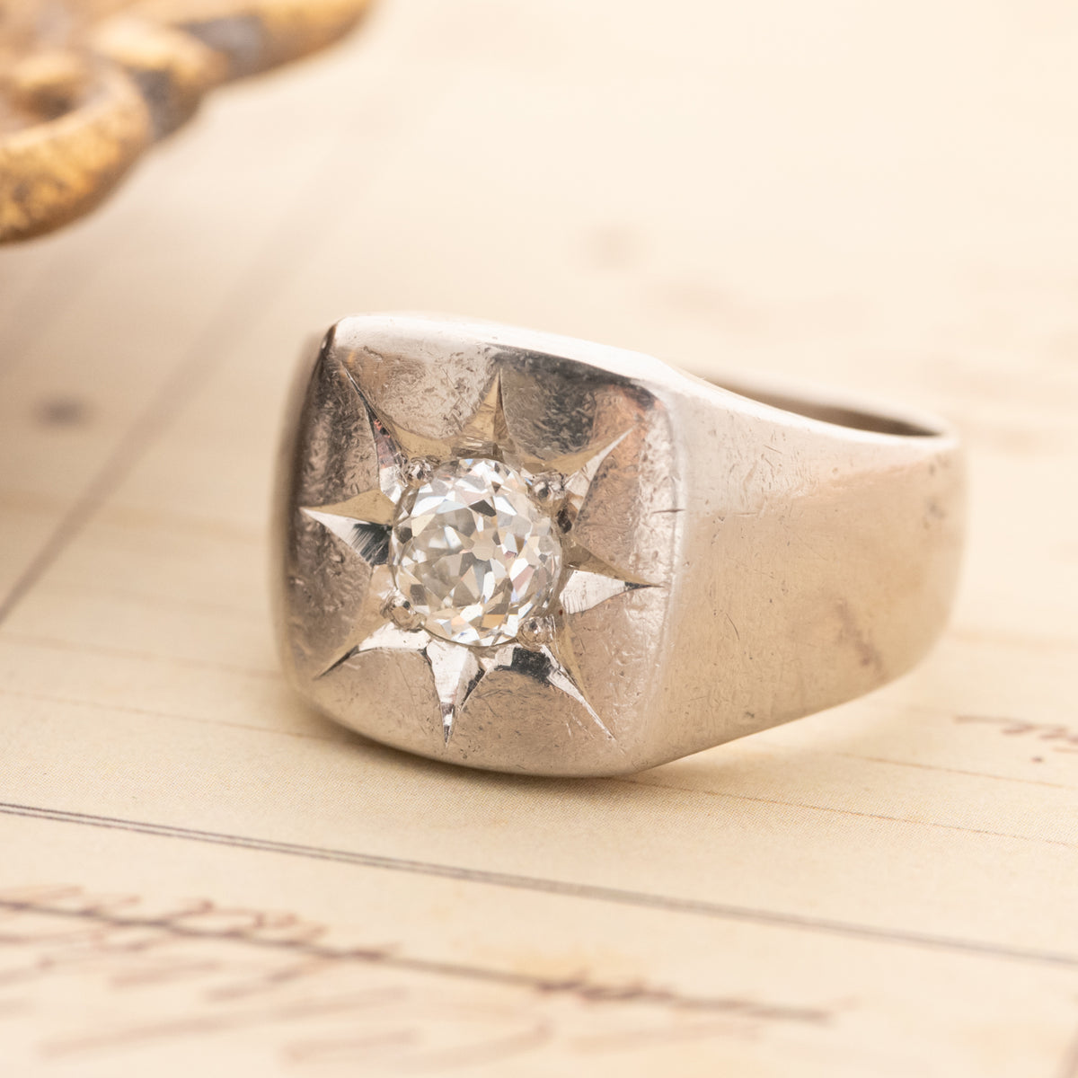 Vintage Star Set Square Signet platinum ring with an Old European Cut diamond in a centered star-shaped engraving.
