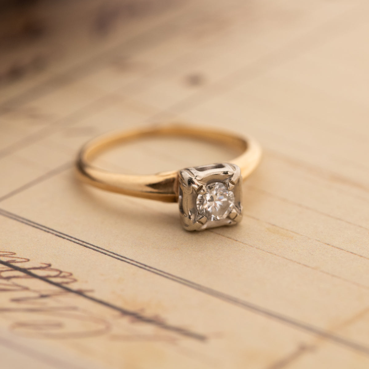 A Vintage Two Tone Diamond Ring featuring a round solitaire diamond, a 14k gold band, and a silver-toned setting.