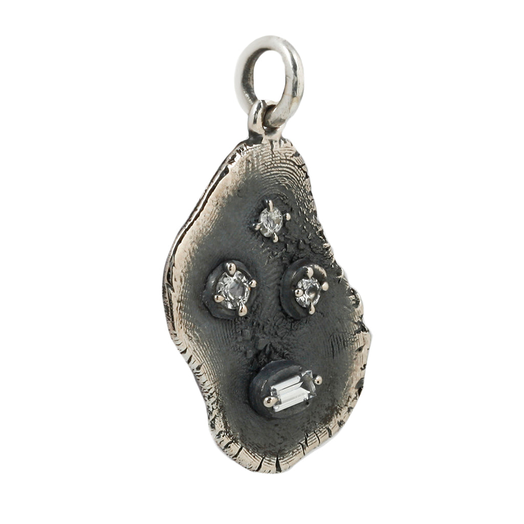 faces pendant by annabelle esptein on a slight side profile with the front still visible