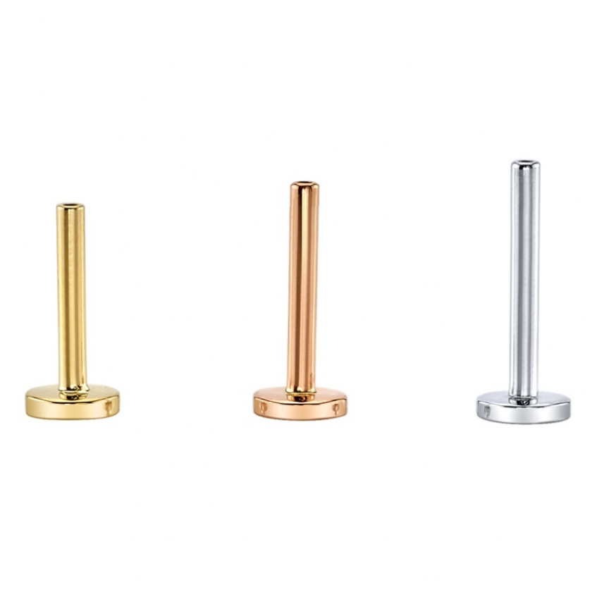 Three flat-back labret piercing posts in gold, rose gold, and silver.