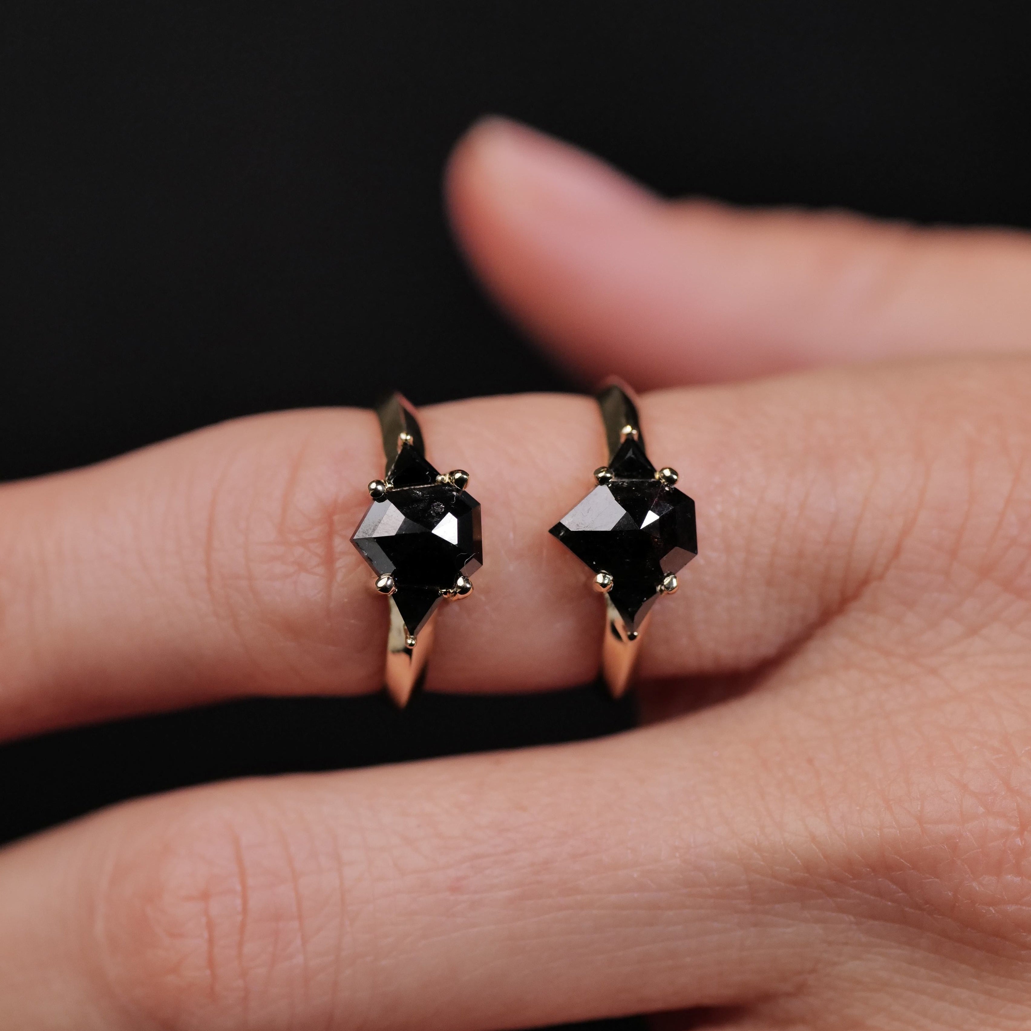 Two Digby & Iona Petite Caliburn rings with 1.46ct black diamonds gleam against a black background.