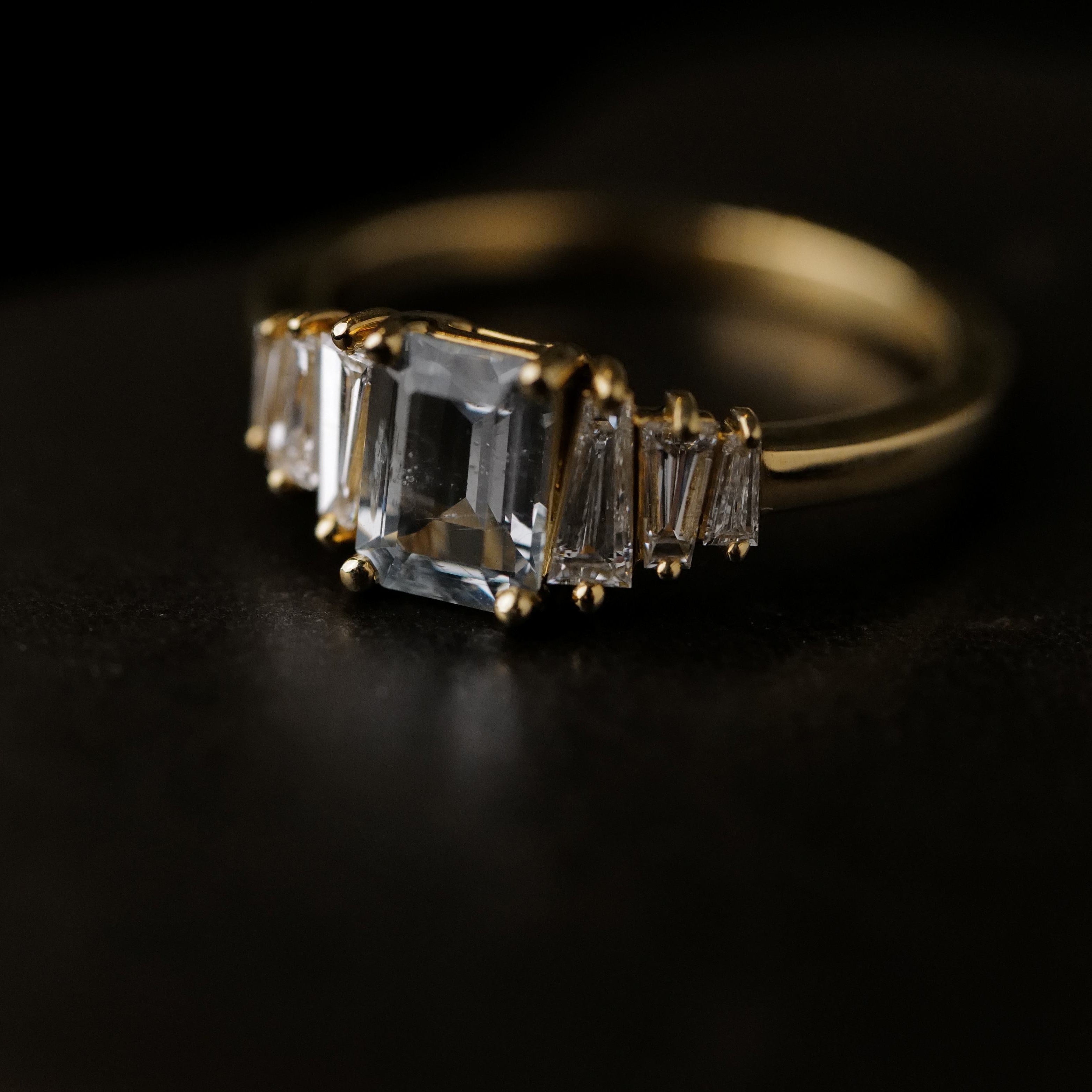 The Fiat Lux Petite Calypso ring features a 1.16ct ice blue sapphire and diamond baguettes on gold.