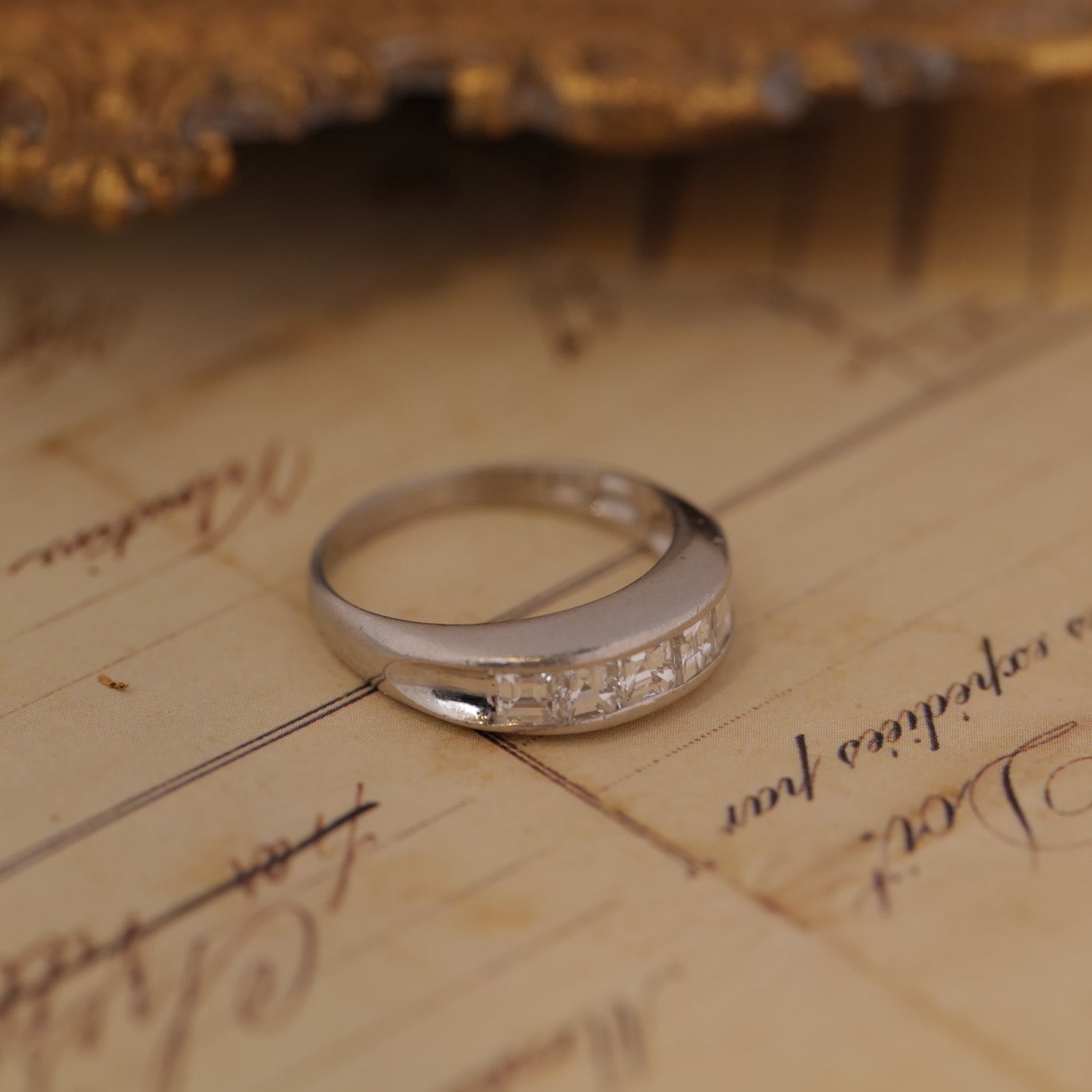 Silver ring with small diamonds on an old, textured paper background