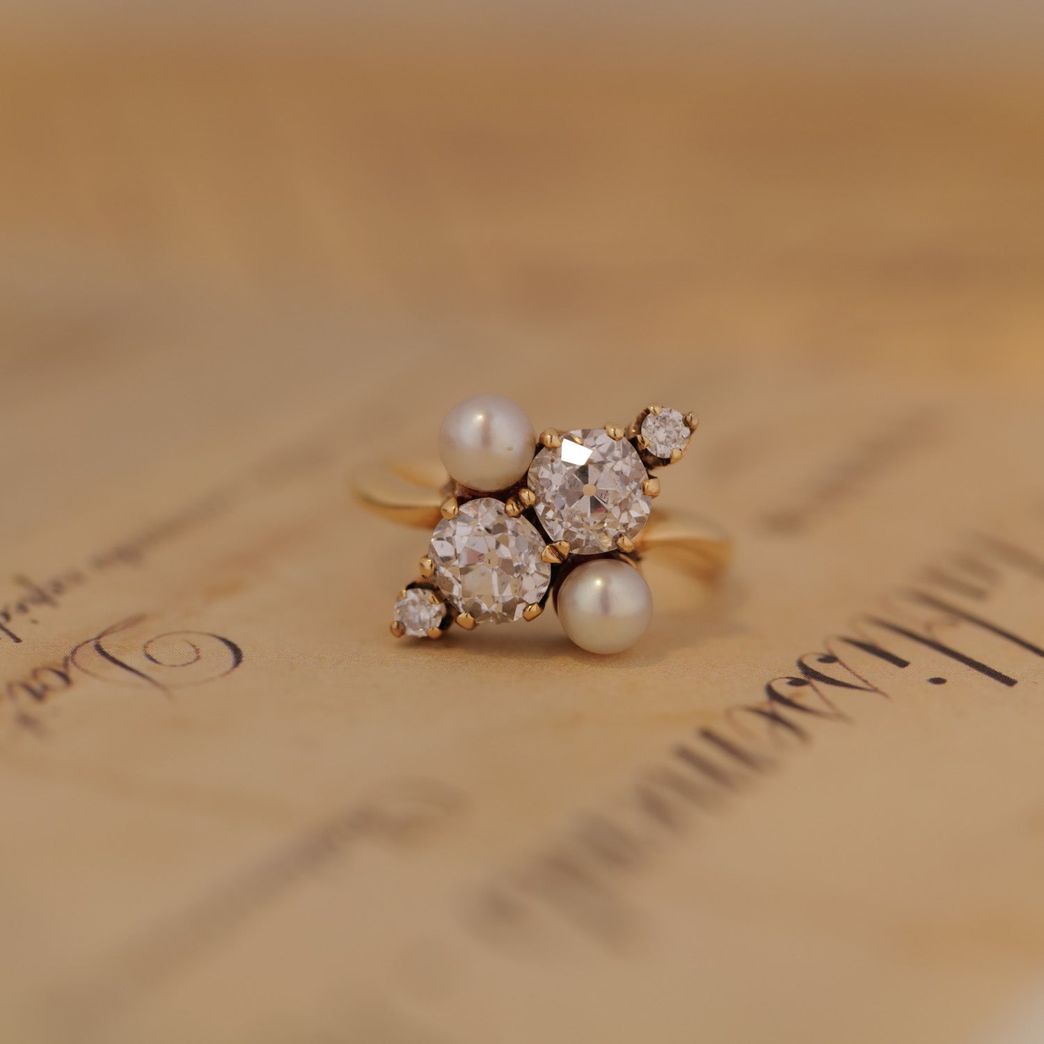 The Vintage Double Pearl Diamond Ring by Vintage rests on vintage handwritten paper.