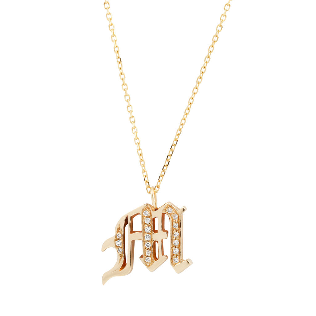Georgie Golds Ideogram Charm: a 14K gold necklace with an M-shaped diamond pendant for classic & gothic jewelry fans.