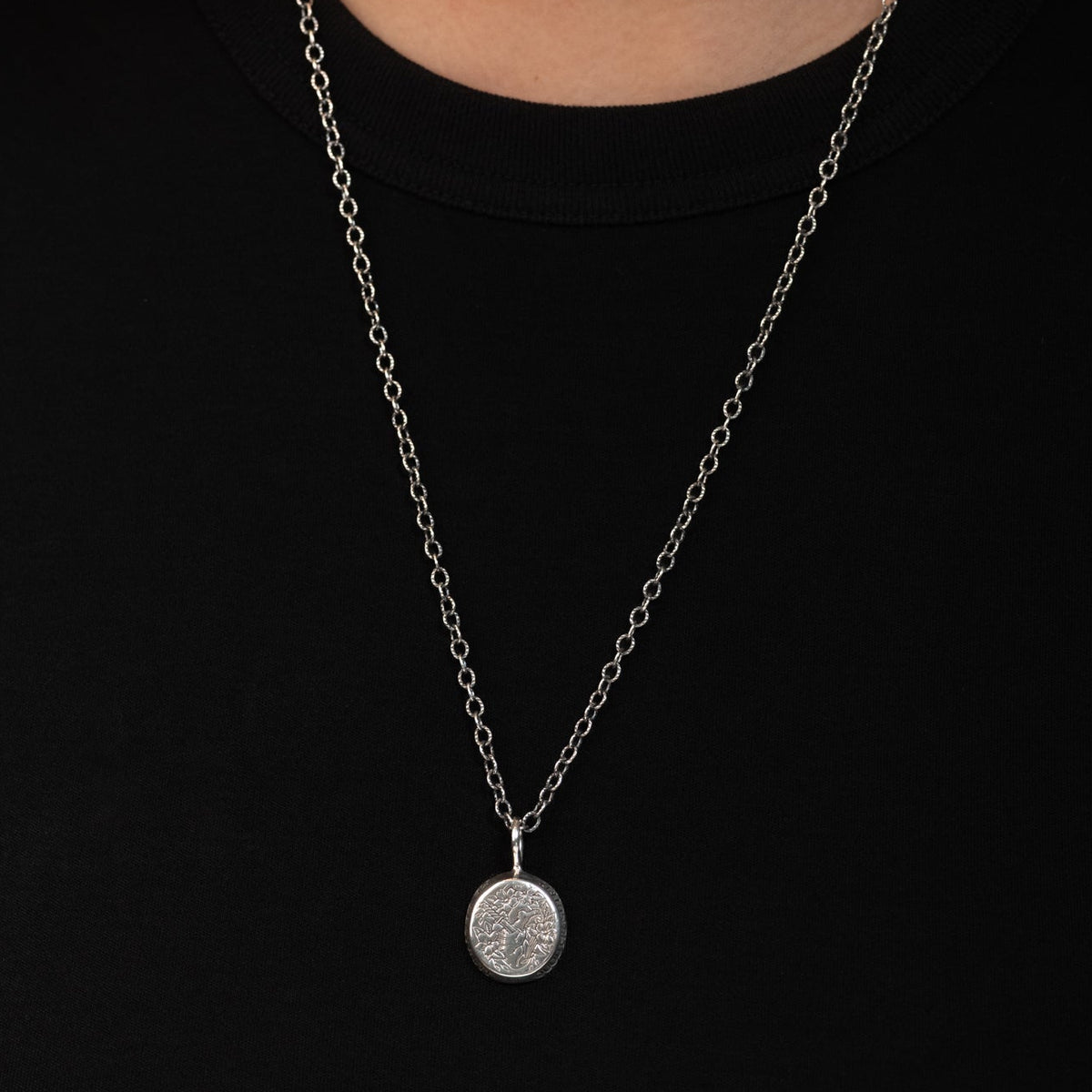 Sterling silver Destruit Necklace with a small round pendant featuring an embossed Quod Me Nutrit Me Destruit design.