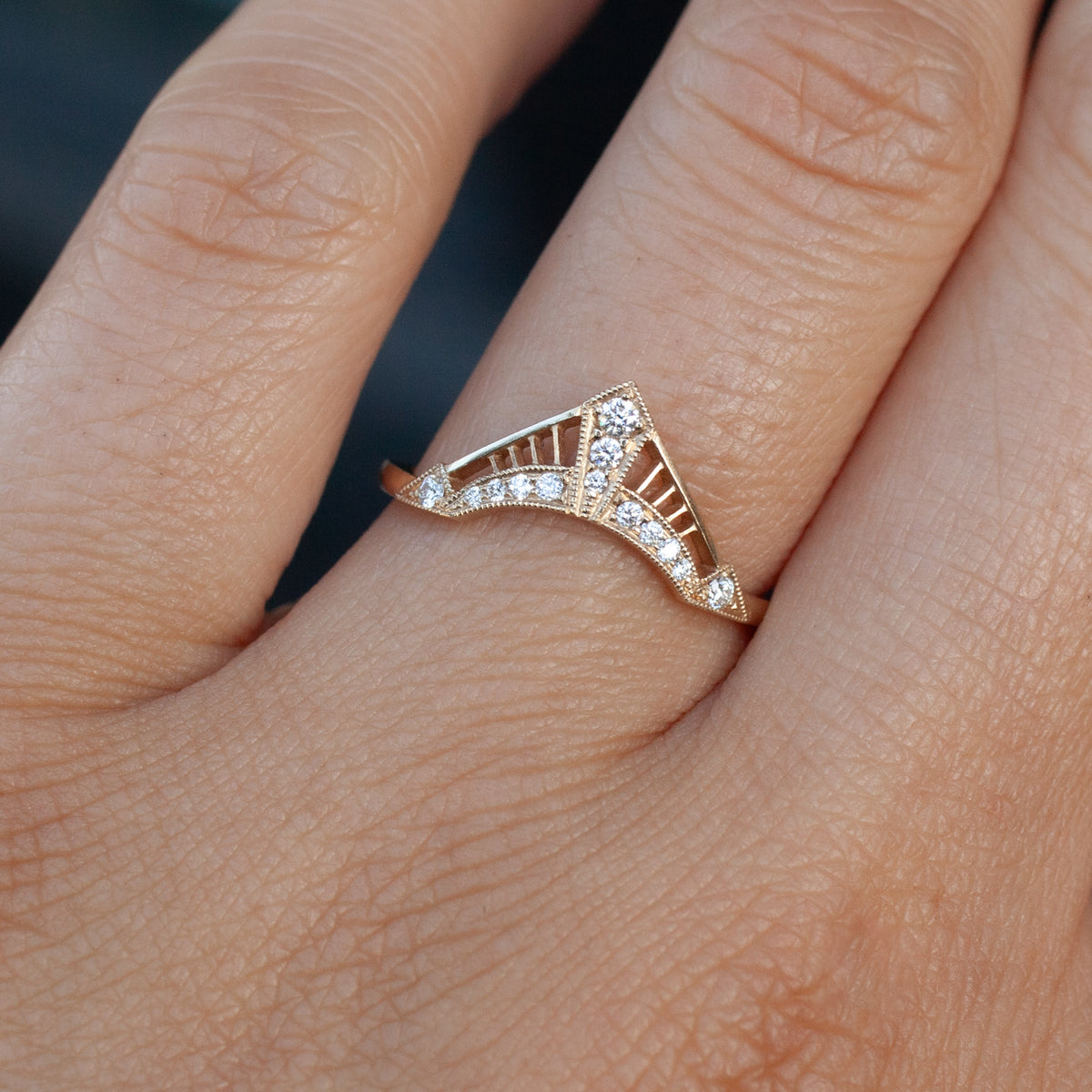 Zilfa Prime Ring - Low Arch with a pointed, V-shaped design, millgrain latticework, and small inlaid stones on a finger.