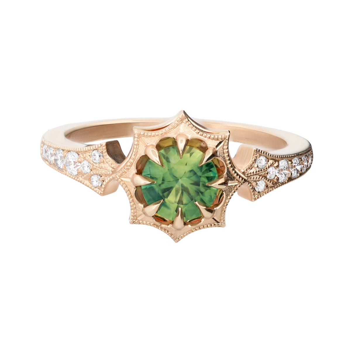 A gold ring featuring a central green gemstone in a starburst cluster setting, flanked by pavé-set clear stones on the band, shown against a plain white background.