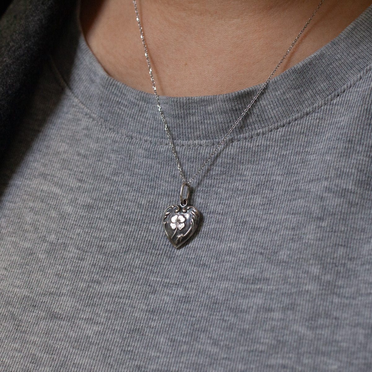 A Fiat Lux Lucky Clover Heart Charm (S) sterling silver heart-shaped pendant with a four-leaf clover on a delicate chain.