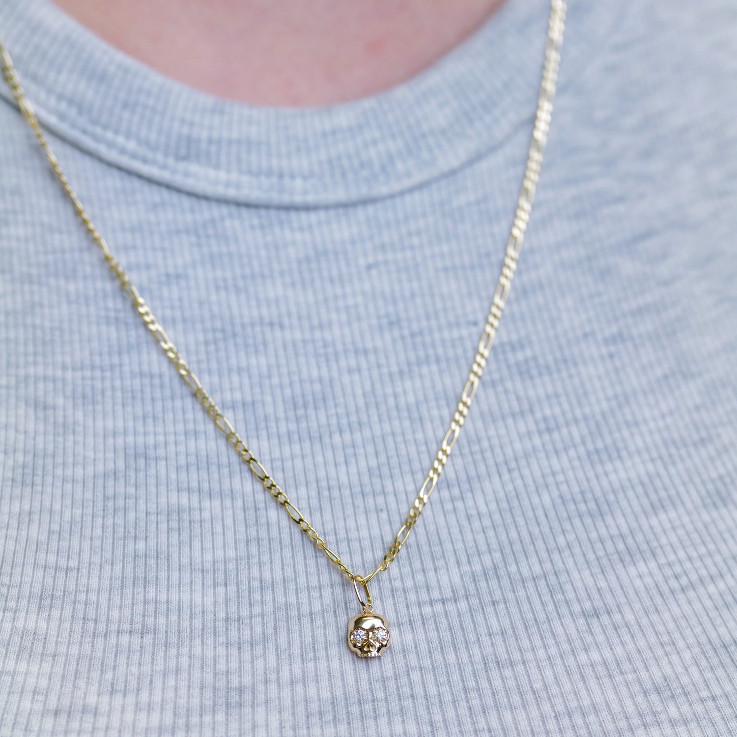 Fiat Luxs The Skull Charm - Classic necklace with 14k gold skull pendant, styled over a light gray ribbed shirt.