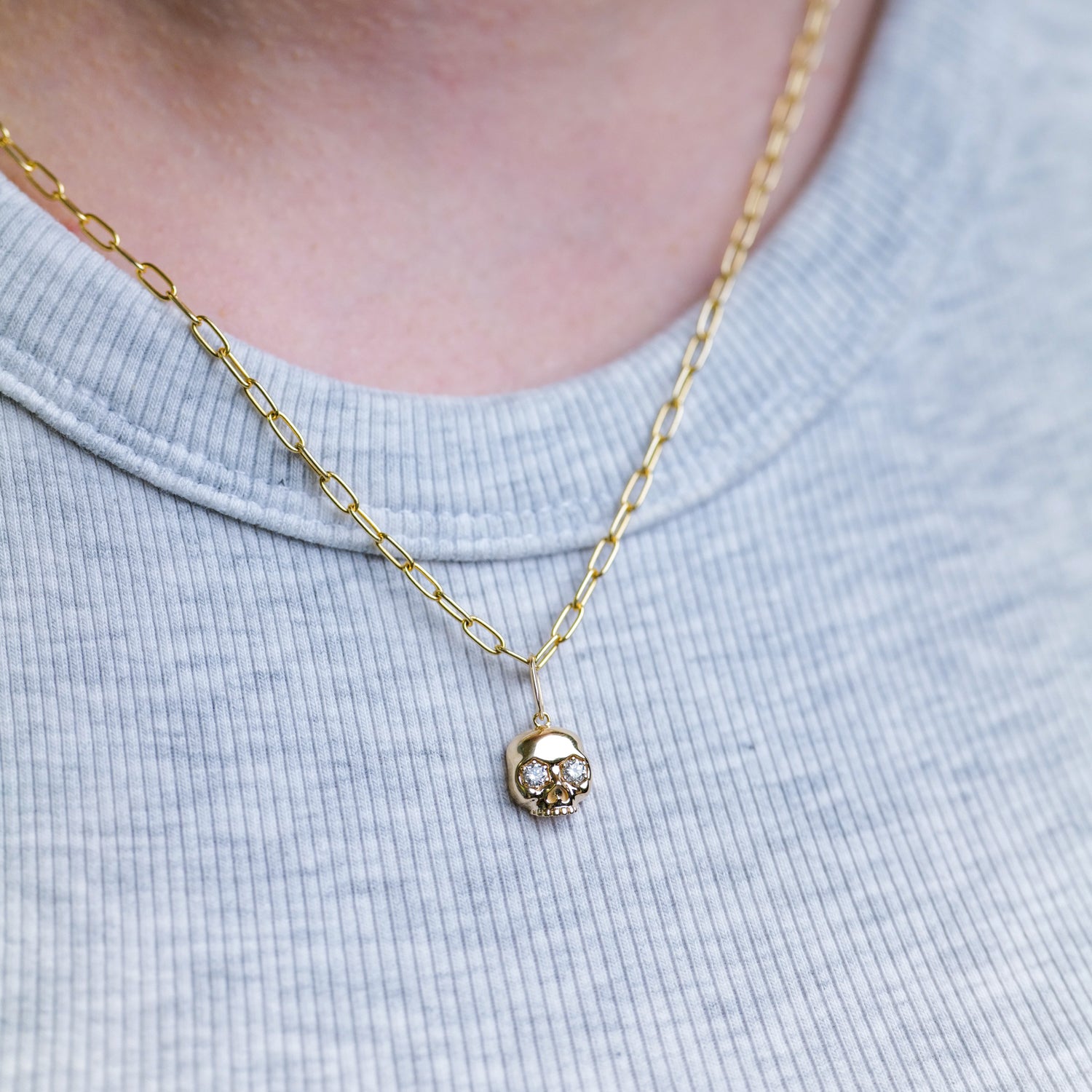 Fiat Luxs The Skull Charm - Grande 14k gold chain, styled over a light gray ribbed shirt.