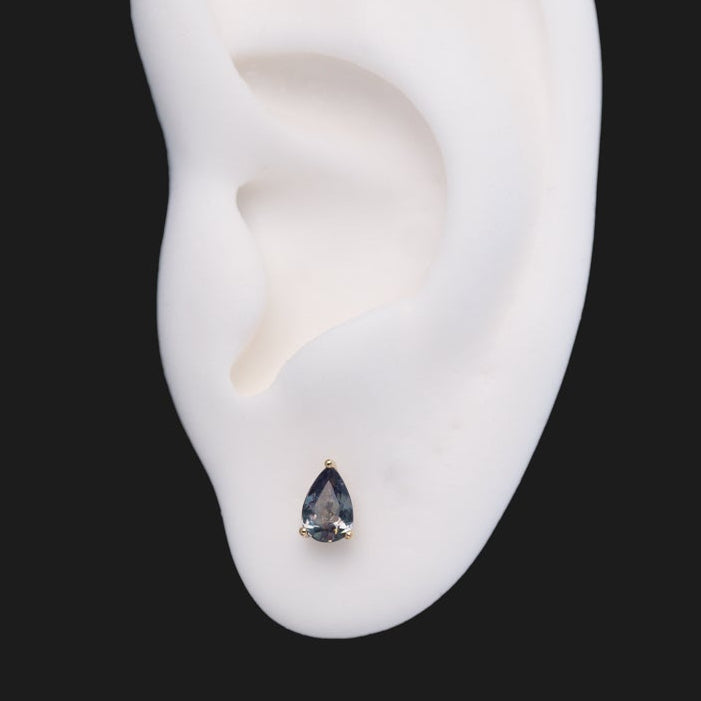 A 3 Prong Pear Grande - Alexandrite (Limited Edition) pear-shaped flatback stud earring in a three-prong setting on an ear.