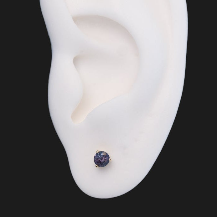 Fiat Lux 3 Prong Round - Alexandrite (Limited Edition) labret stud with a dark purple gem in a white ear model.