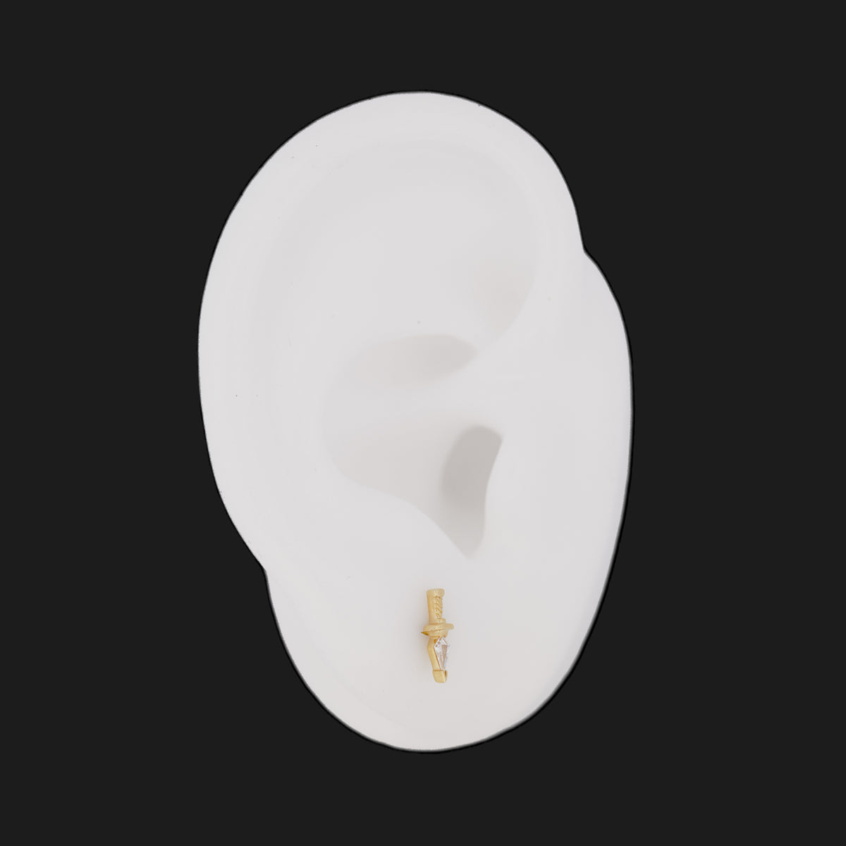 Fiat Lux Kite Dagger Stud: a 14K gold dagger-shaped earring with a kite-cut diamond flatback on a white mannequin ear.