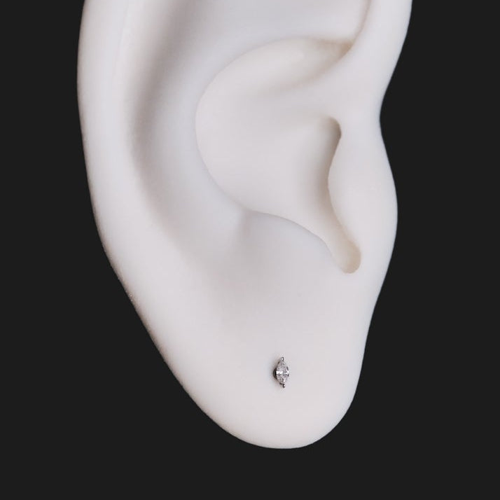 A white ear model featuring a Petite Marquise Prong - White Diamond labret in the earlobe.