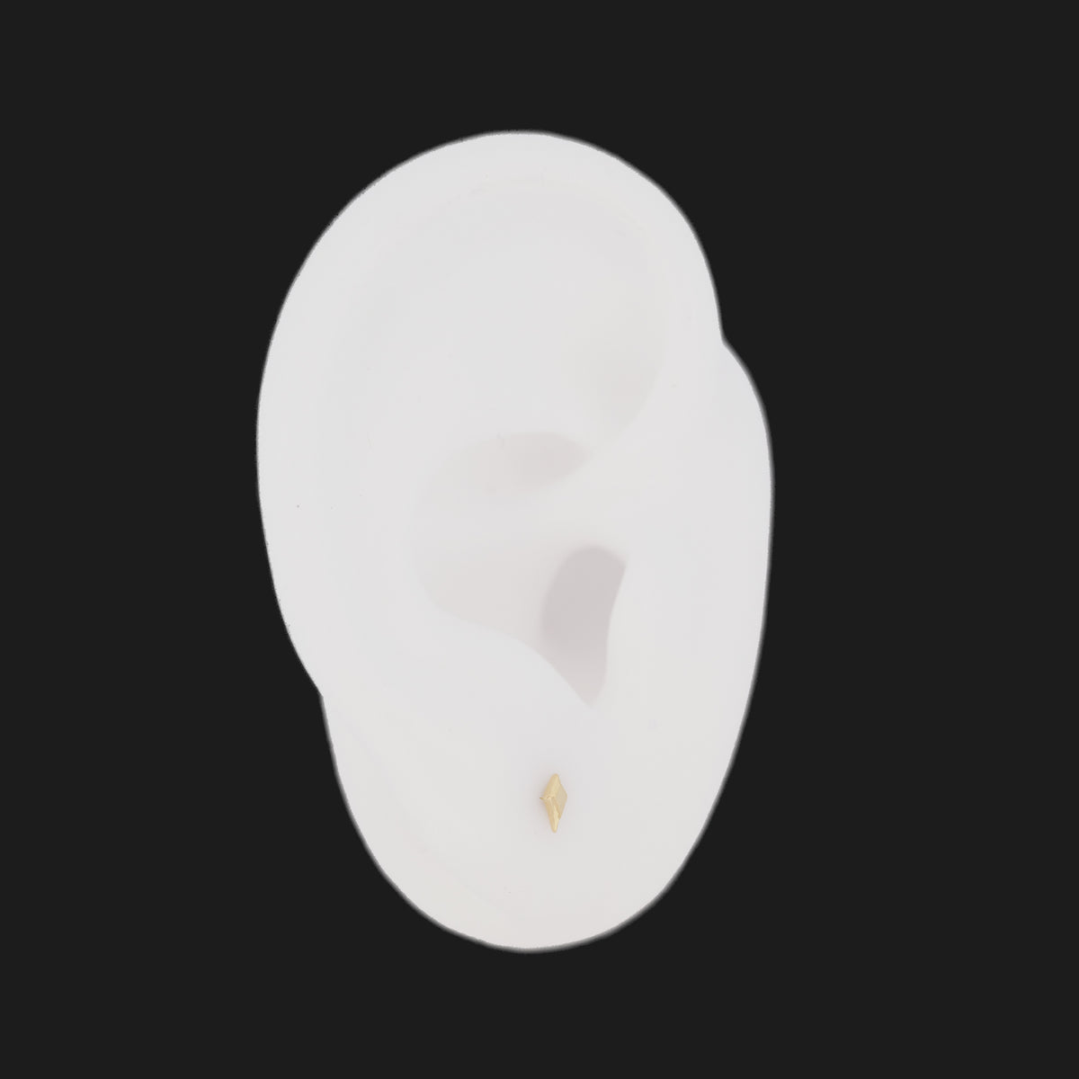 A small 14K gold Petite North Star Earring worn on a white model ear.