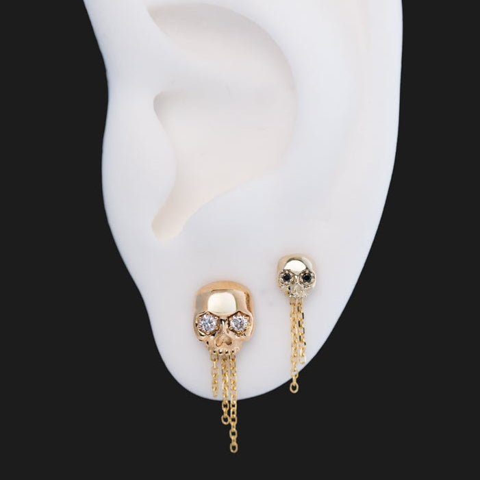 Fiat Lux The Skull Stud - Classic earrings with dangling chains: one with clear stones and the other with dark stones.