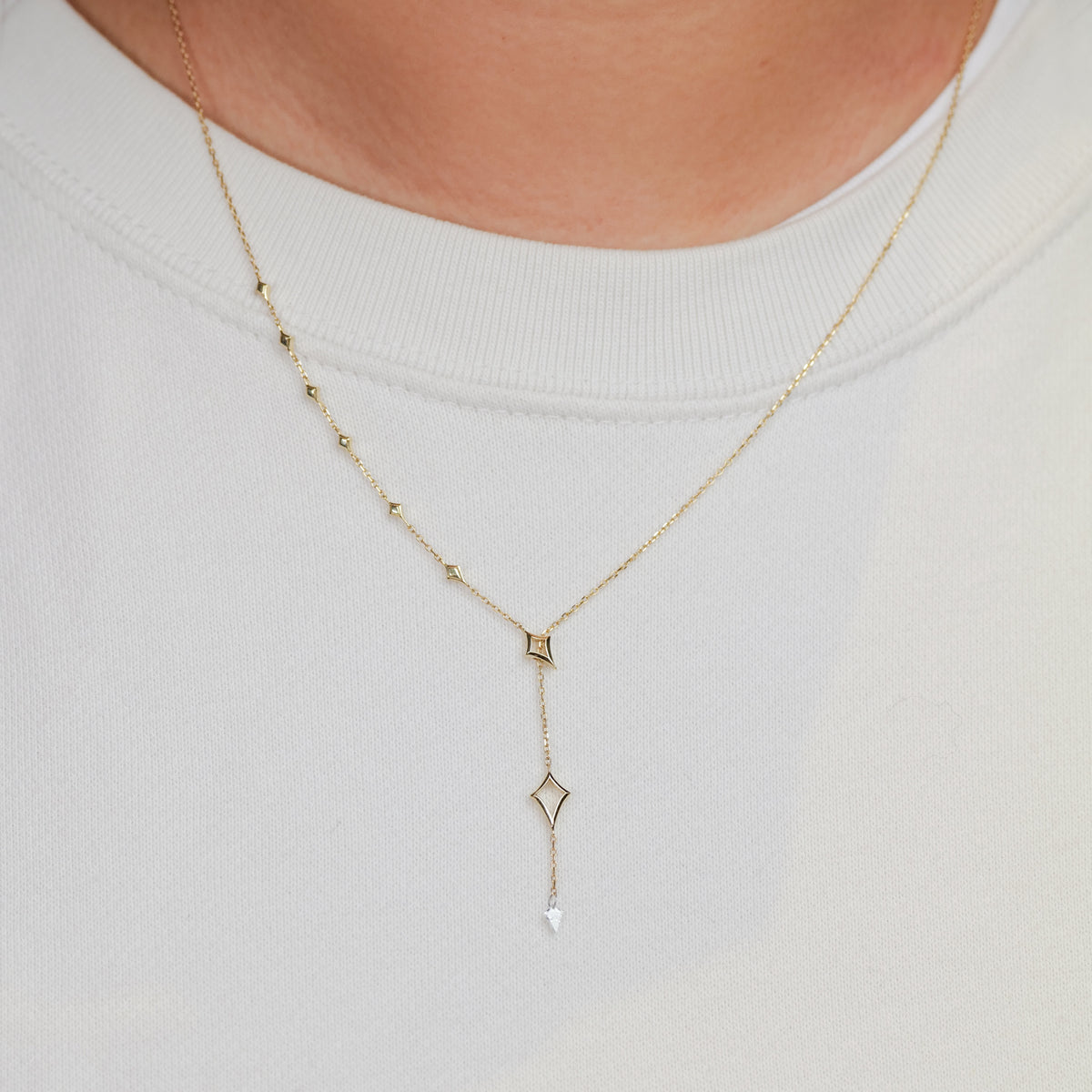 Fiat Lux North Star Lariat Necklace—white diamond drop adds constellation-inspired brilliance over a plain white top.
