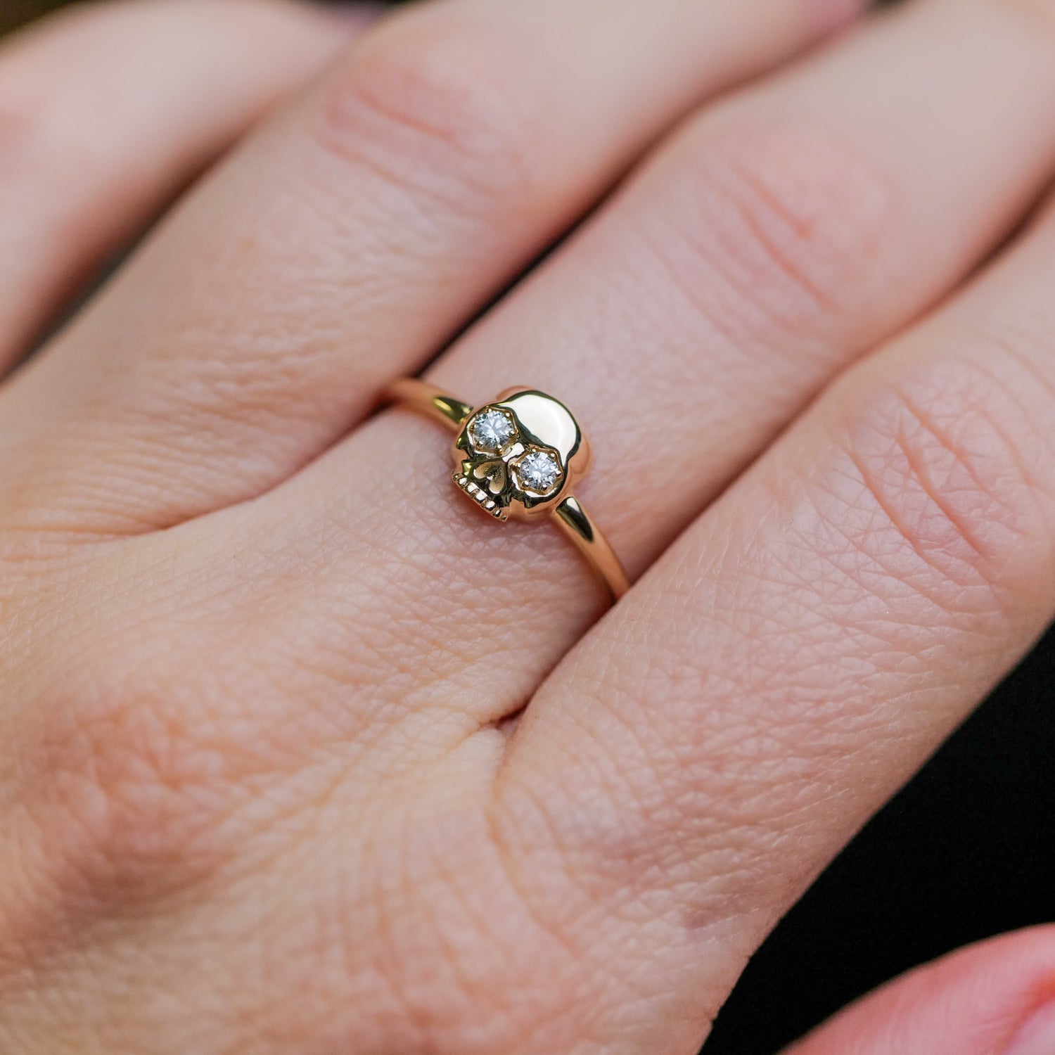 The Skull Ring by Fiat Lux: a 14k gold skull with gemstone eyes and striking white diamond accents.