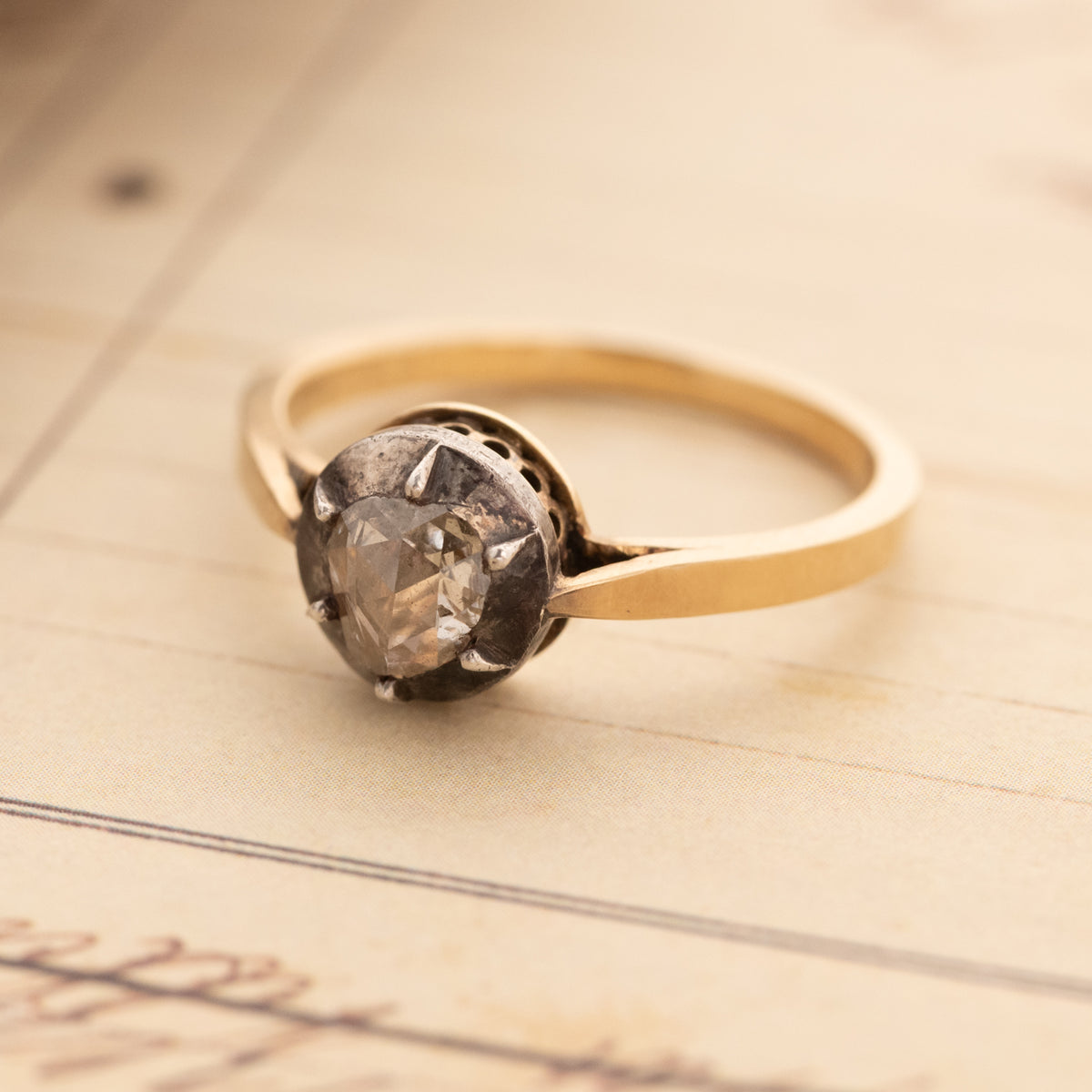 Antique Cut Down Collet Diamond Ring with a rose cut diamond in a dark, scalloped collet setting.