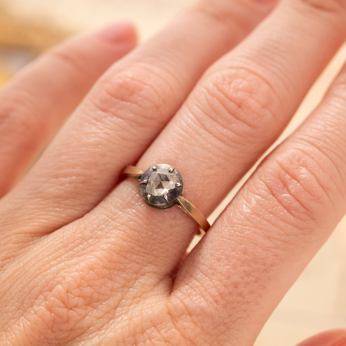 An Antique Cut Down Collet Diamond Ring, an antique Victorian rose-cut diamond ring in a pronged collet setting on a finger.