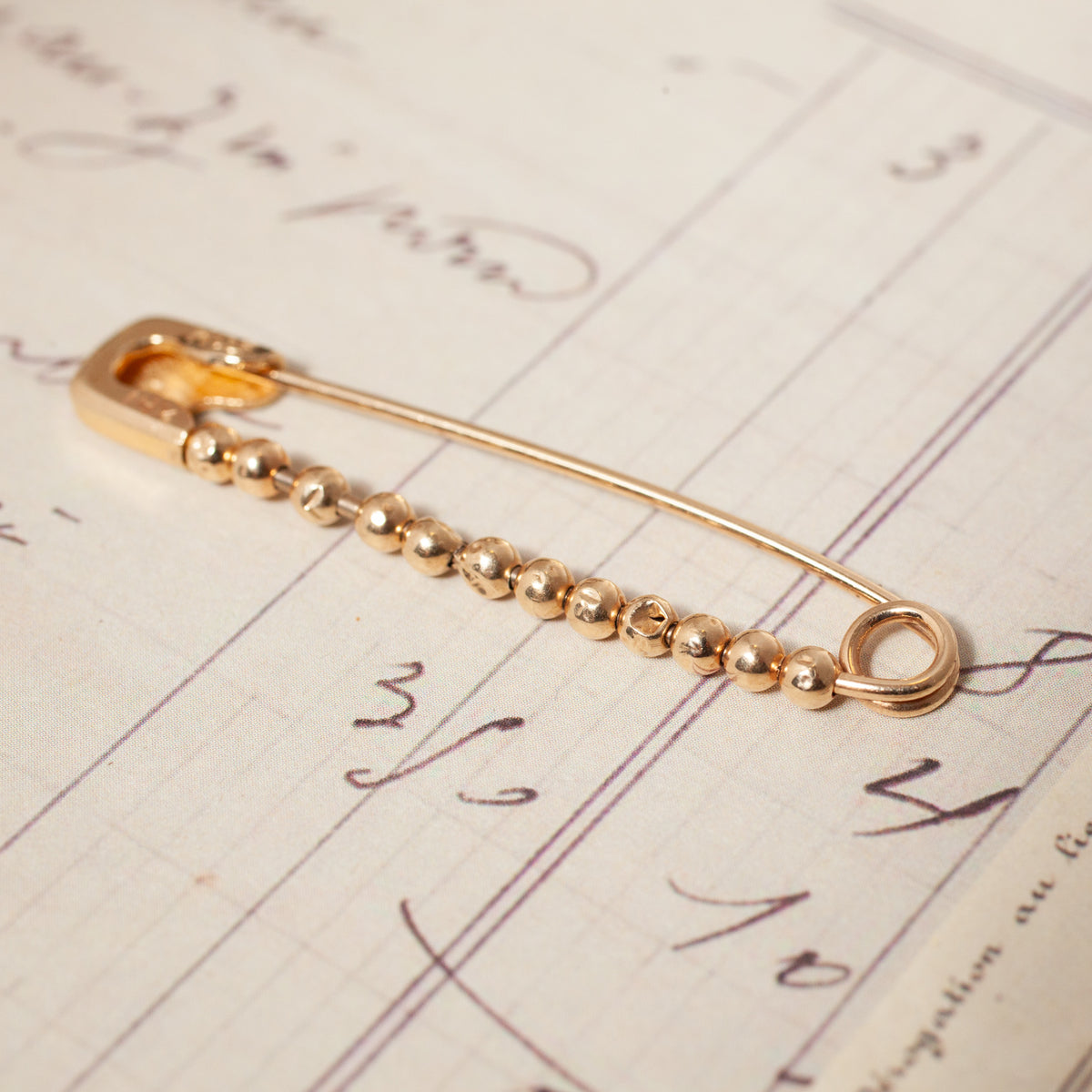 A 14K gold Vintage Beaded Safety Pin featuring a row of small metallic beads along its bottom bar.