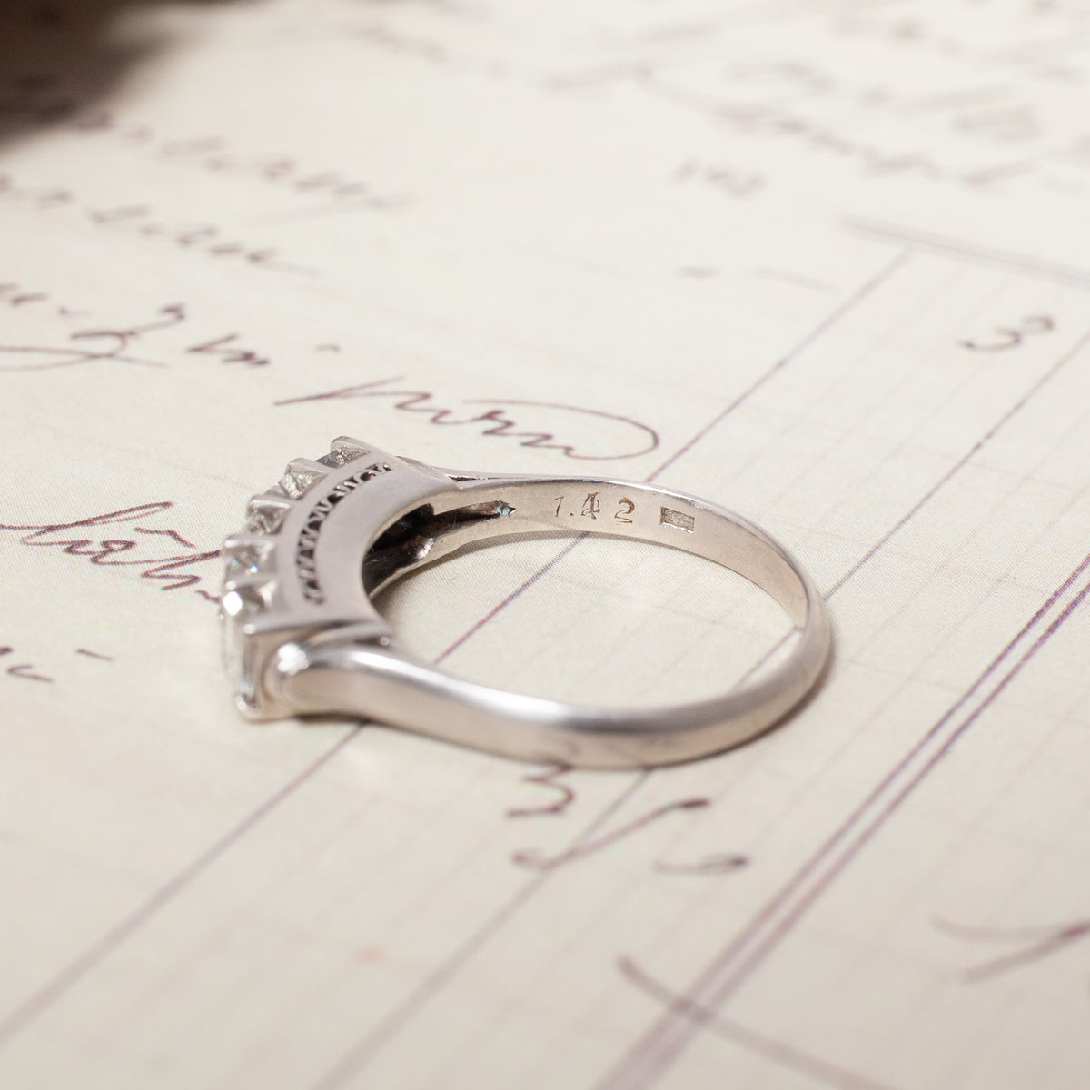 Vintage Carré Cut Diamond Band - 4.5mm in platinum with 5 stones resting on handwritten paper.