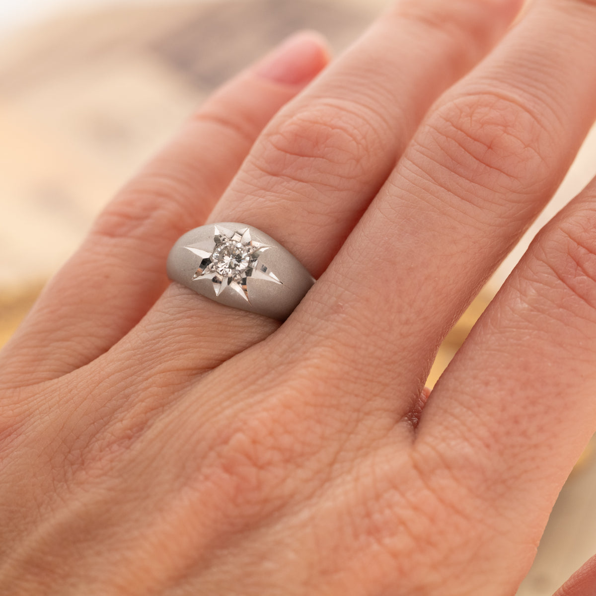 A Vintage Domed Star Set Diamond Ring: a wide platinum band with a brilliant cut diamond in a star-shaped engraving.
