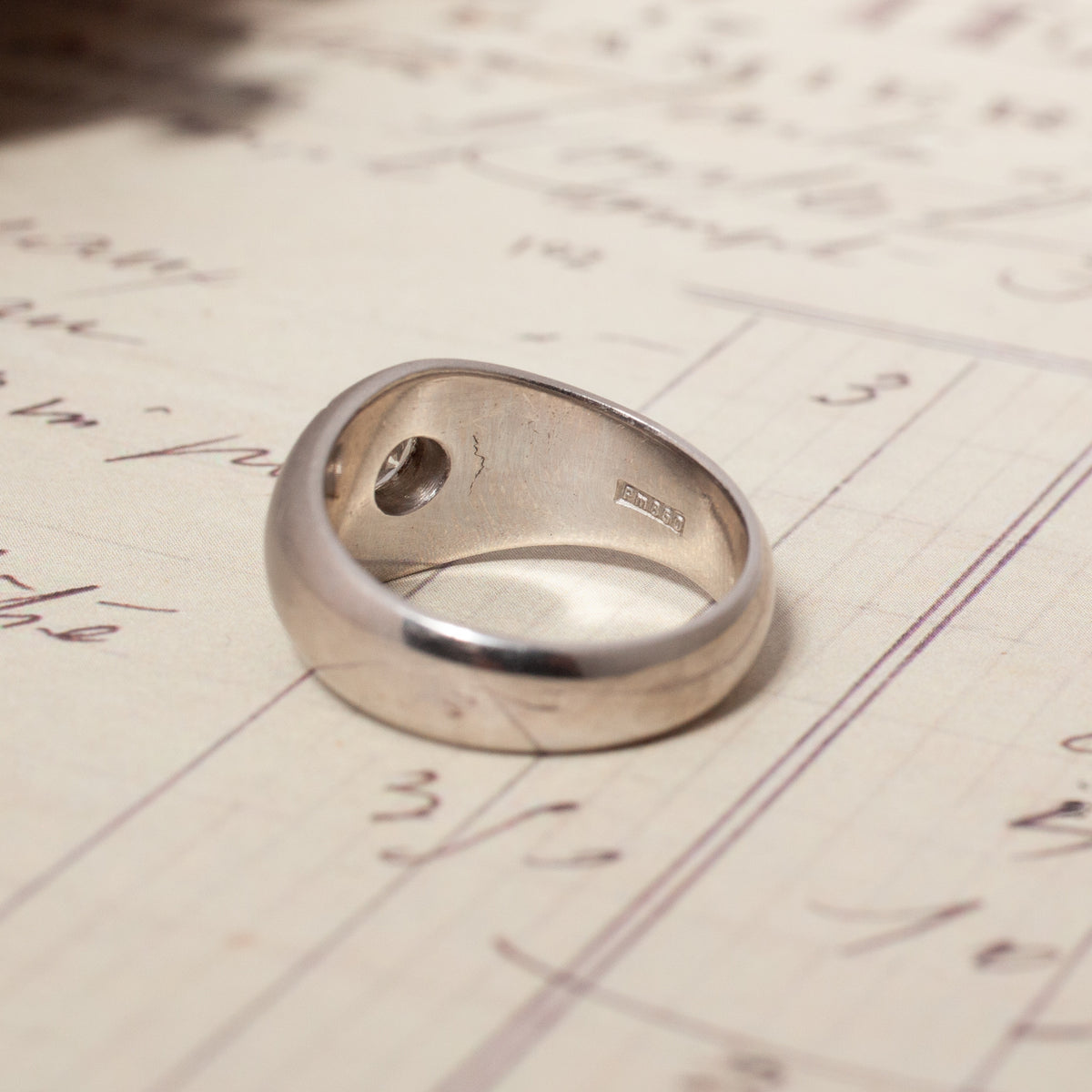 Back view of a Vintage Domed Star Set Diamond Ring, showing a wide platinum band with hallmark details inside the shank.