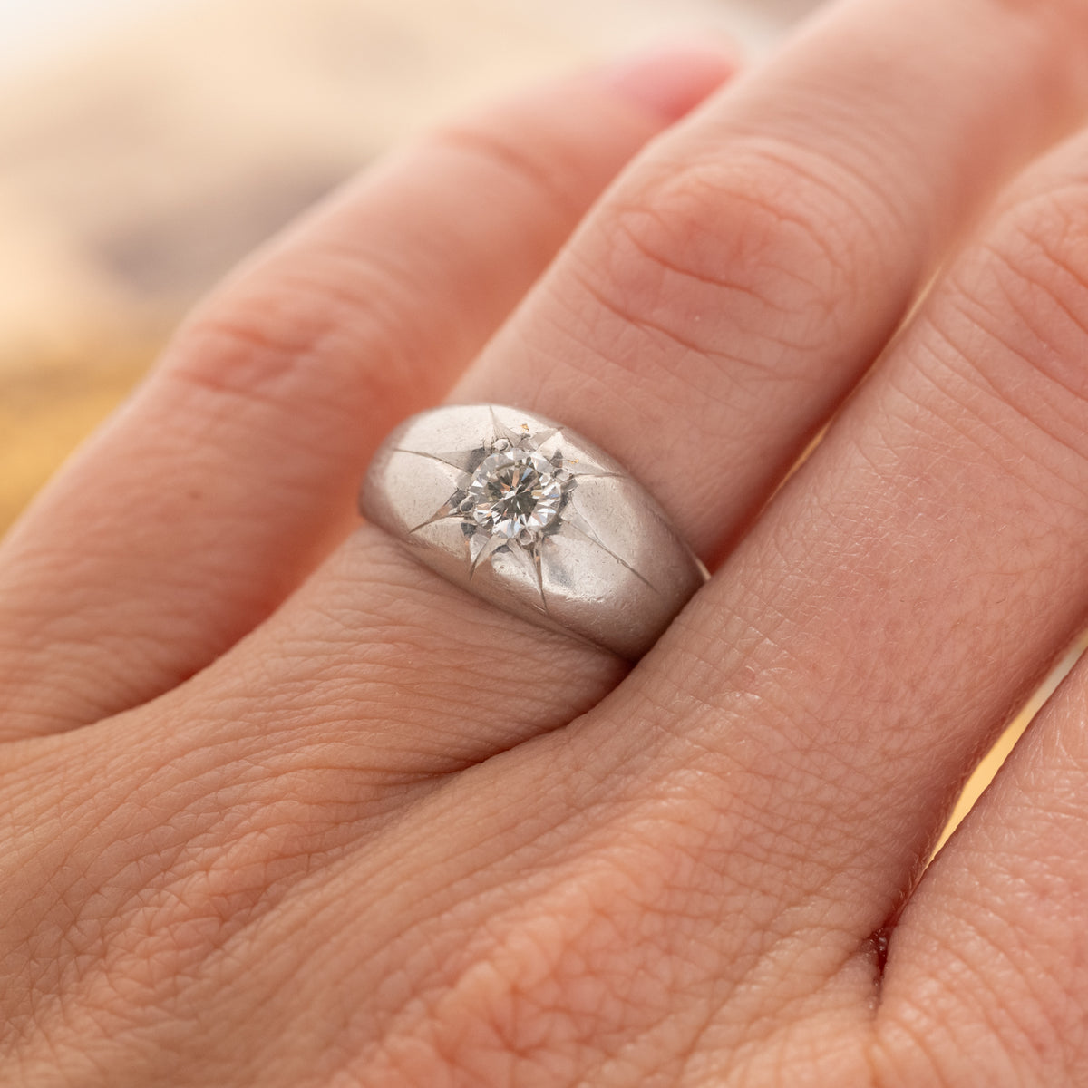 Vintage Star Set Bombe ring in platinum, featuring a brilliant cut diamond in a star-shaped engraving on a rounded band.