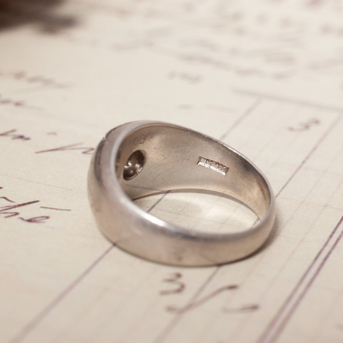 A Vintage Star Set Bombe platinum PT900 domed ring with a brilliant cut diamond and a hallmark on the inside band.