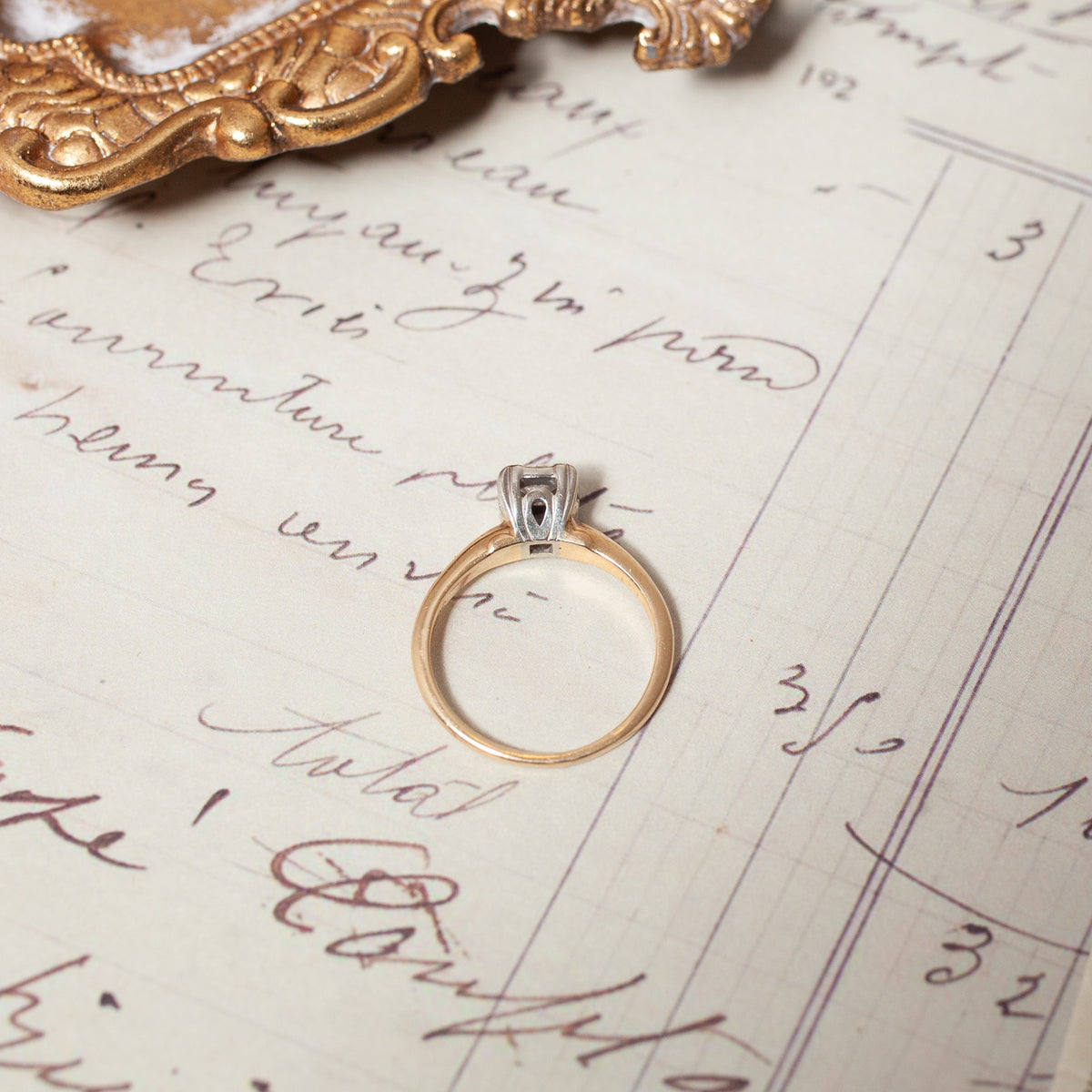 Vintage Two Tone Diamond Ring featuring a two-tone 14k gold band with a modern diamond setting on a vintage document.